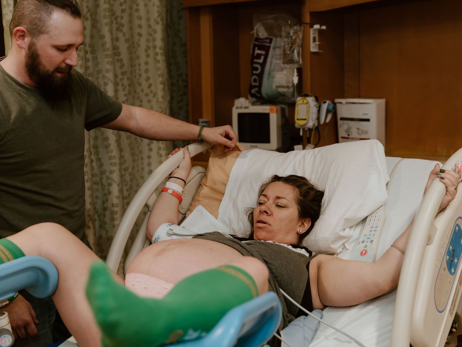 Medical care being provided to a patient in a hospital room setting with green accents.