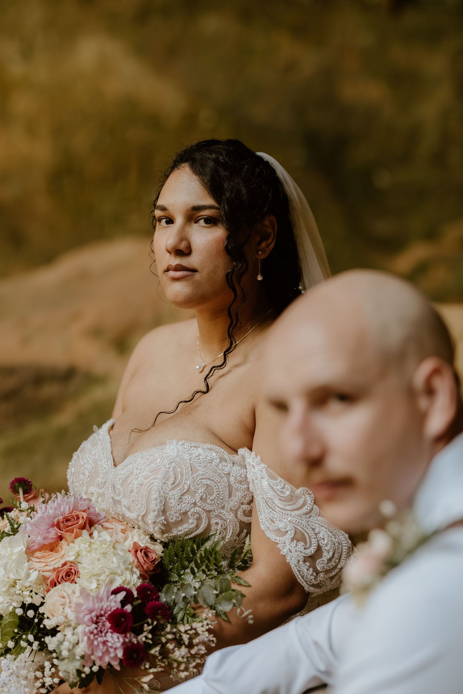 A romantic outdoor wedding photo series showing a couple with a beautiful bouquet of pink and burgundy flowers.