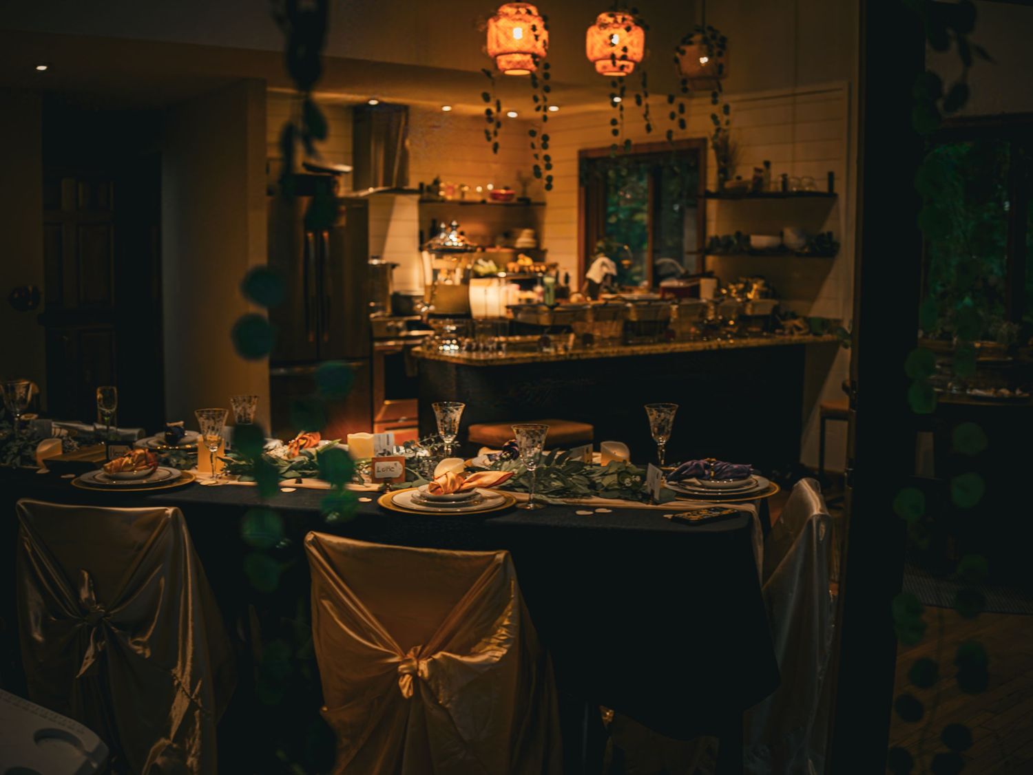 Moody reception venue setup with warm lighting and elegant table settings.