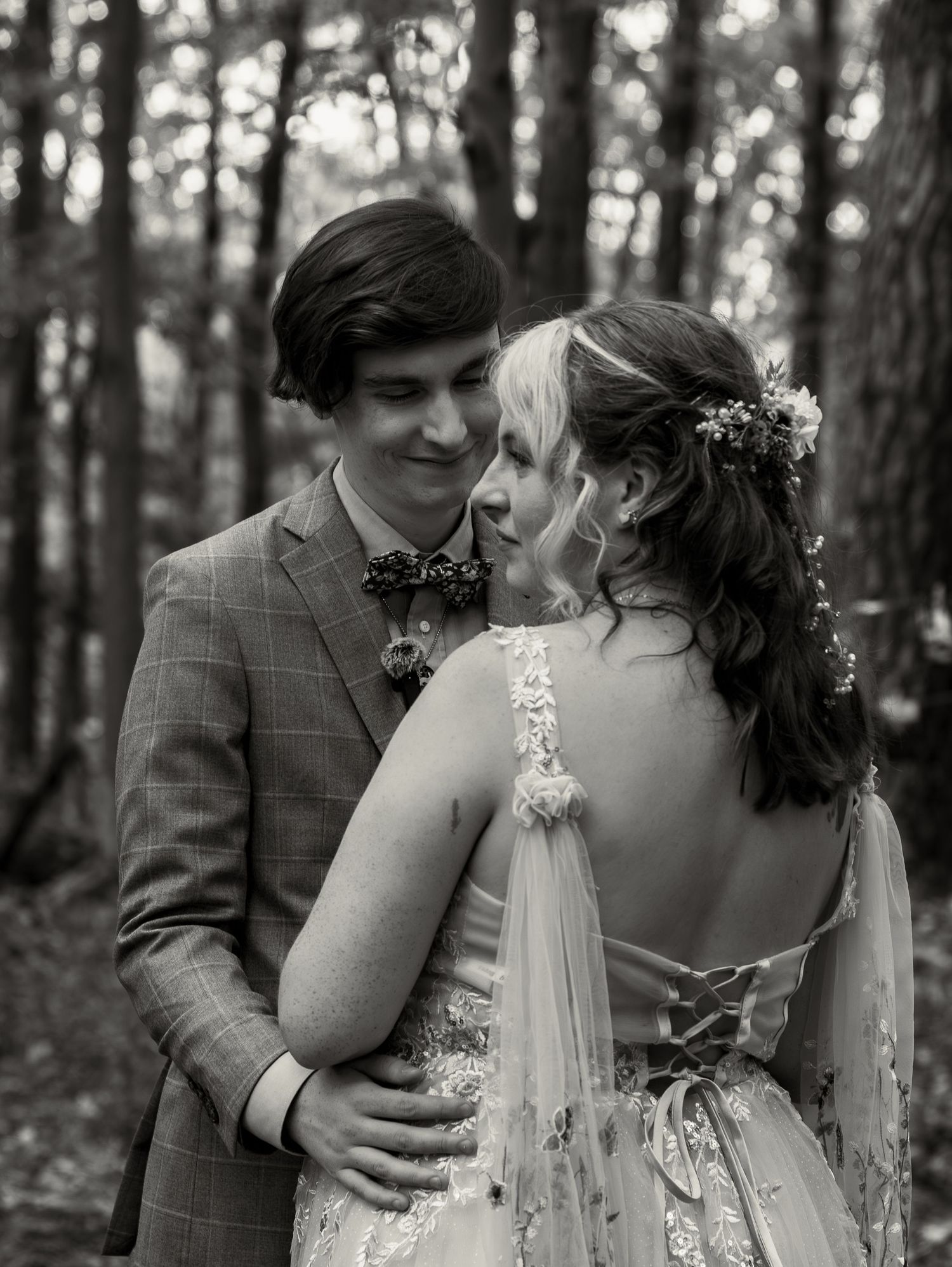 A romantic black and white wedding photo sequence showing tender moments between newlyweds in a forest.
