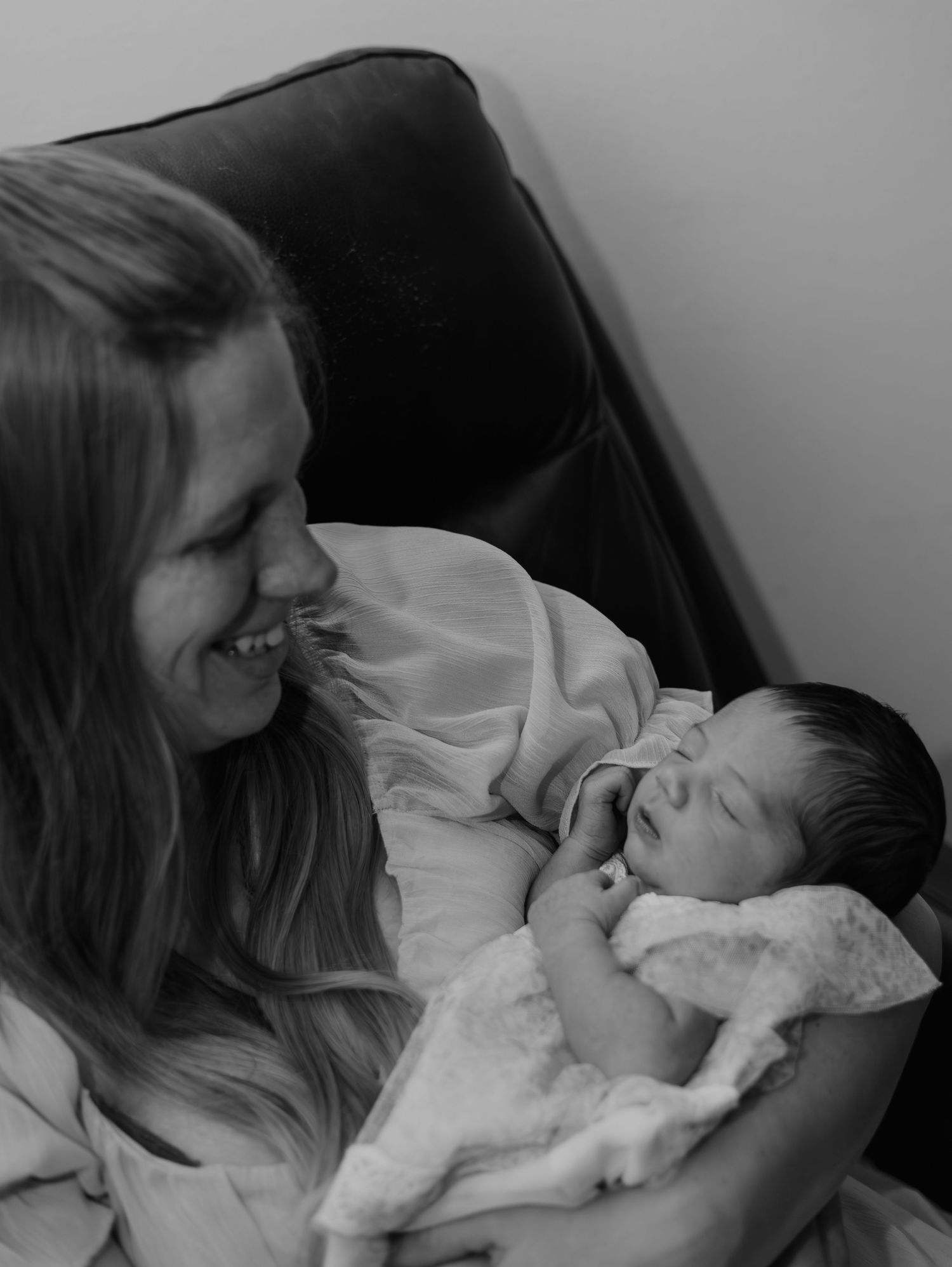 Black and white portrait of a tender moment with a sleeping newborn.