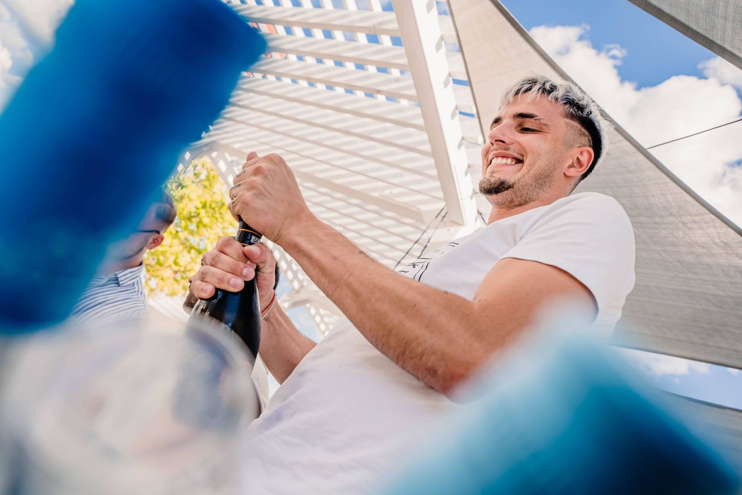 Party scene outdoors with festive drinks and bright blue sky.