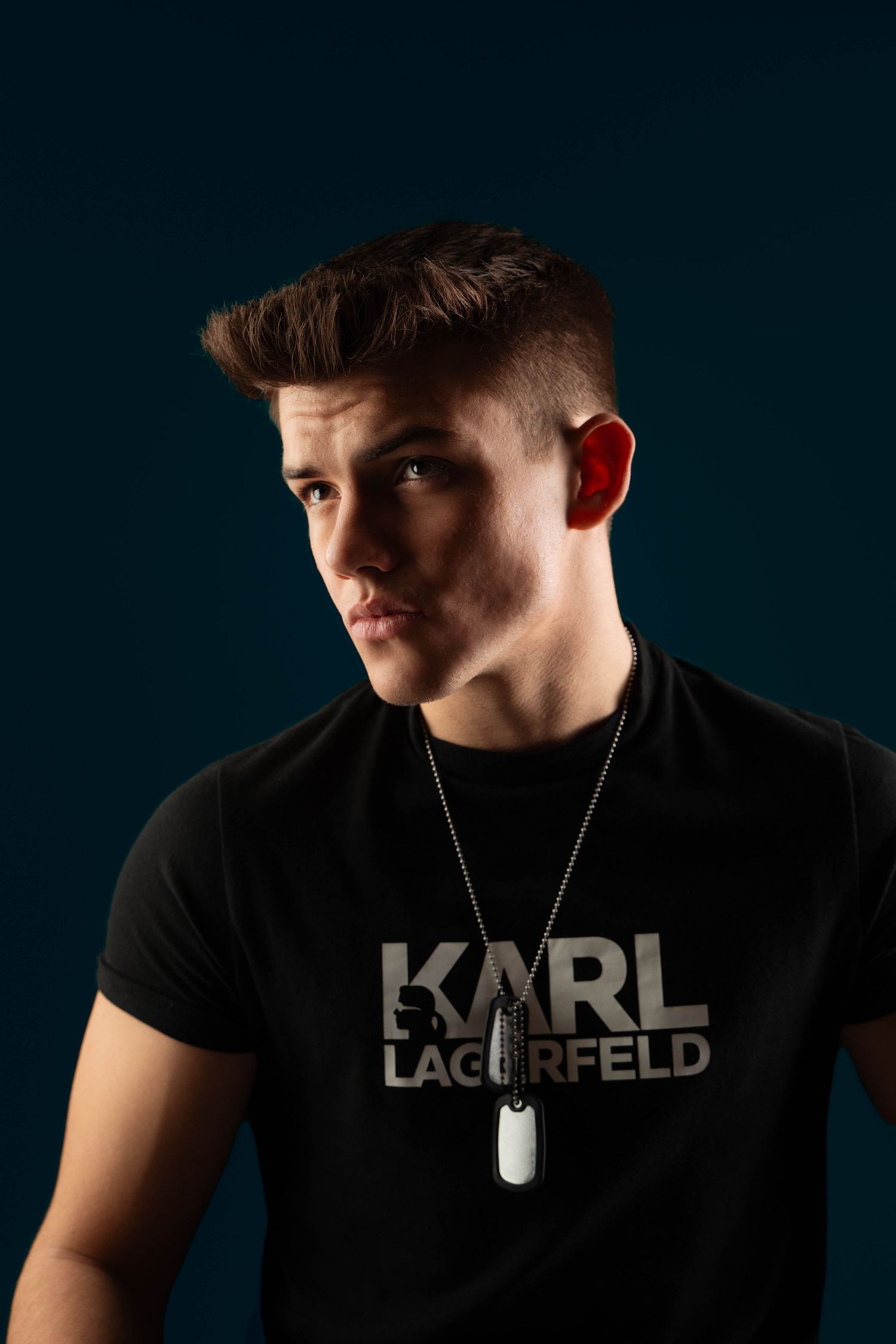 Portrait of model wearing Karl Lagerfeld t-shirt against dark background.