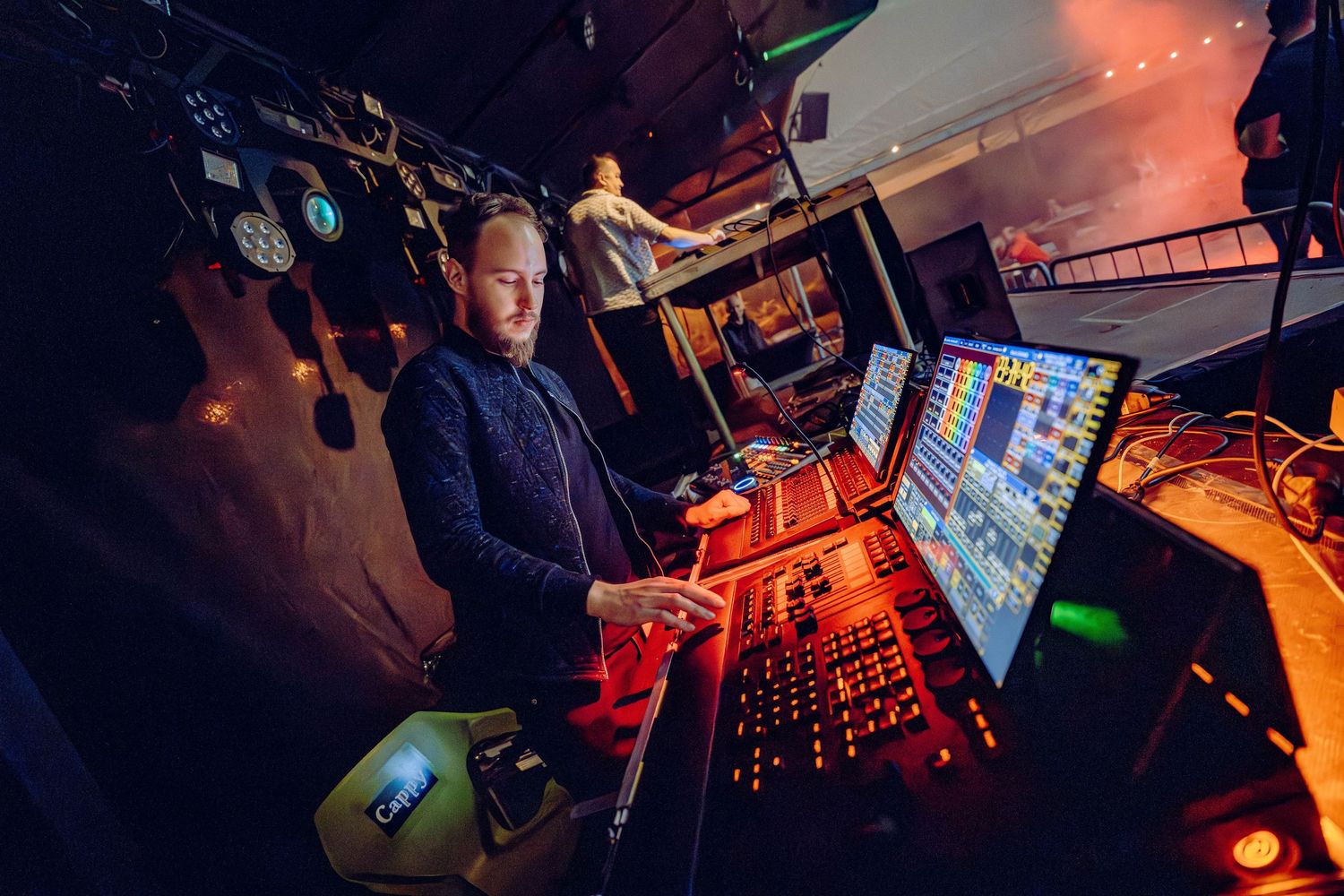 DJ performs at a nightclub with professional audio equipment and colorful lighting creating an energetic atmosphere.