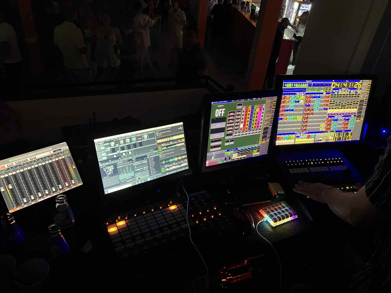 Dark control room with multiple computer monitors displaying technical data and colorful interfaces at night.