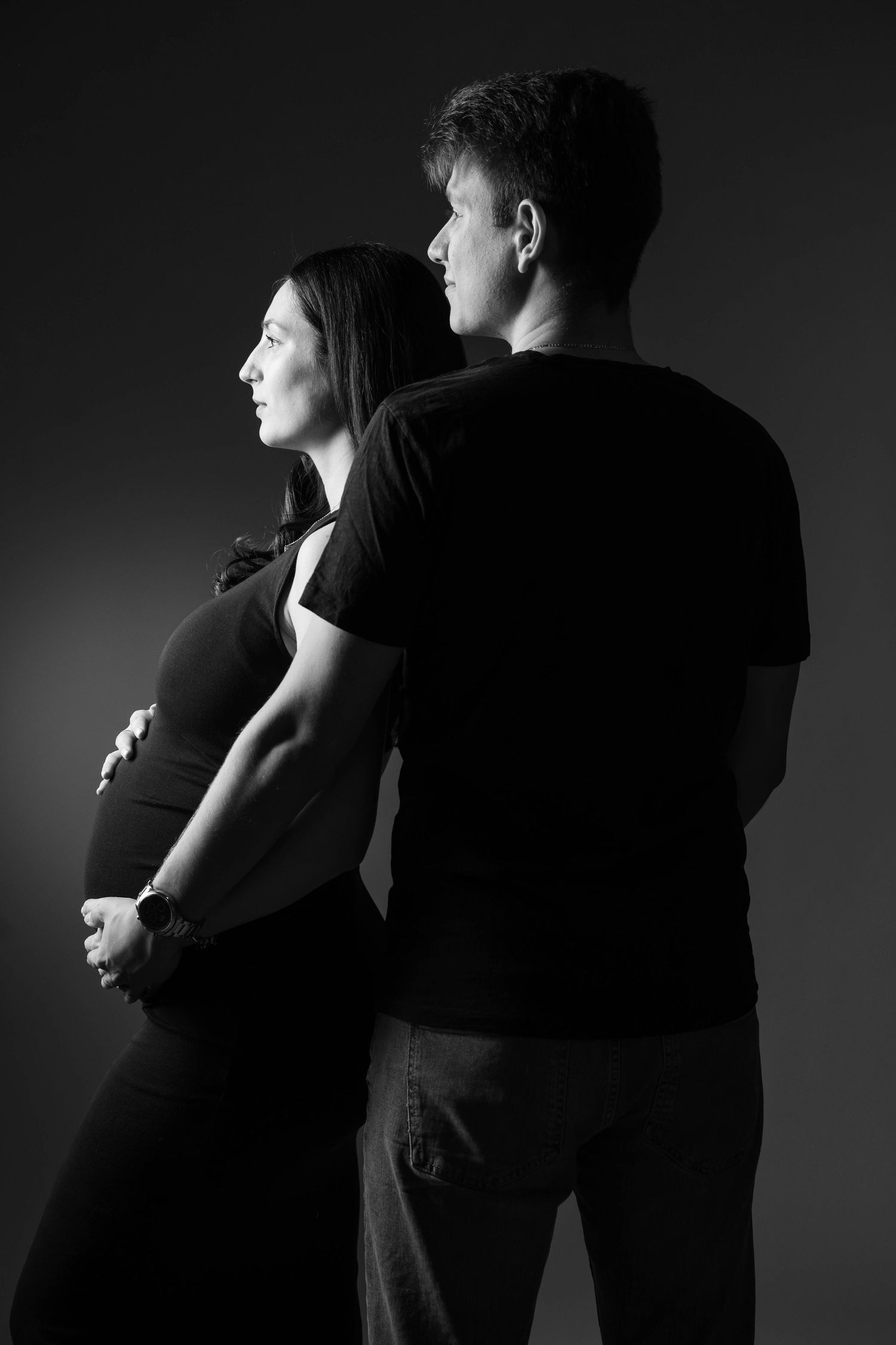 Dramatic black and white photo series showing a couple embracing in silhouette against dark background.