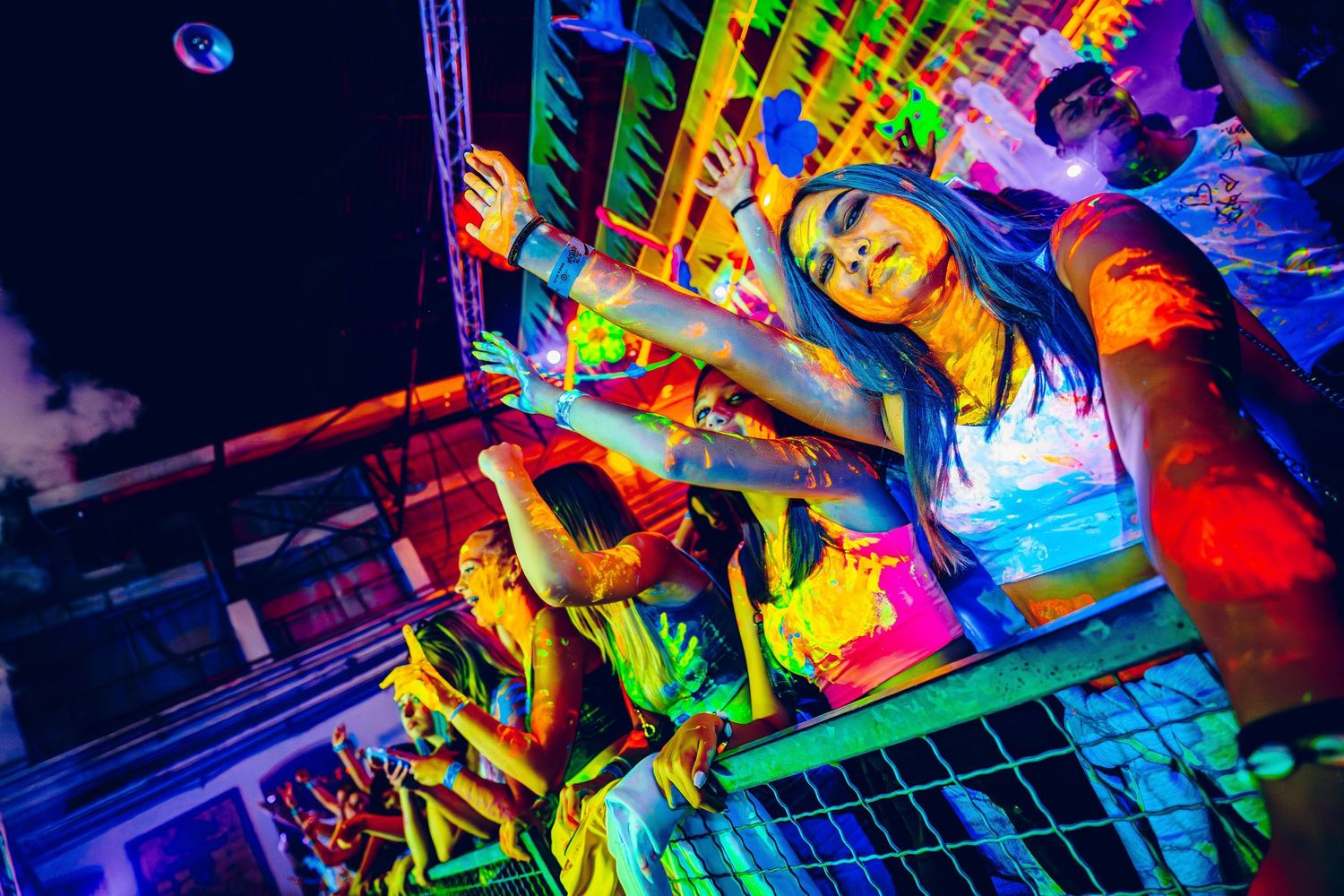 Vibrant neon-lit dance party scene with colorful lighting effects.