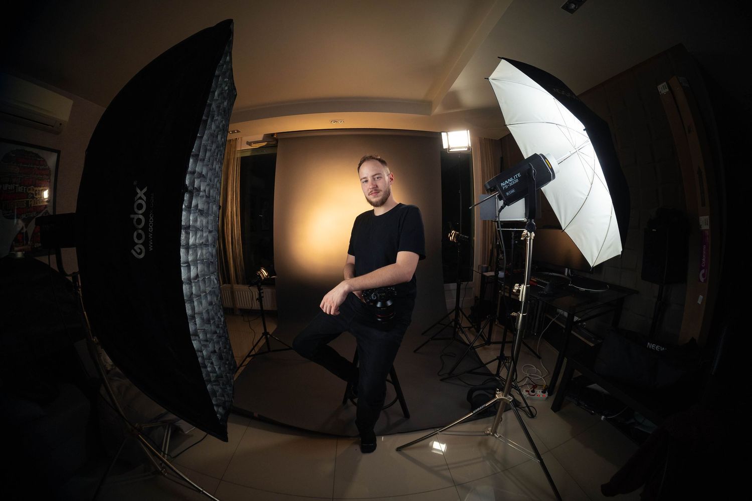 Behind-the-scenes photo studio setup with lighting umbrellas and fisheye perspective.
