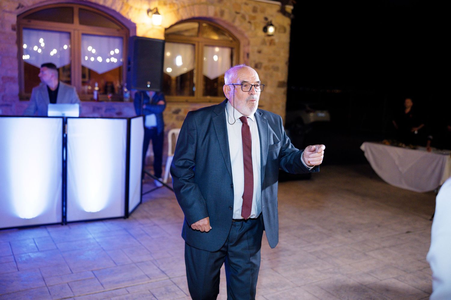 Wedding reception in a rustic stone venue with ambient lighting and formal attire.