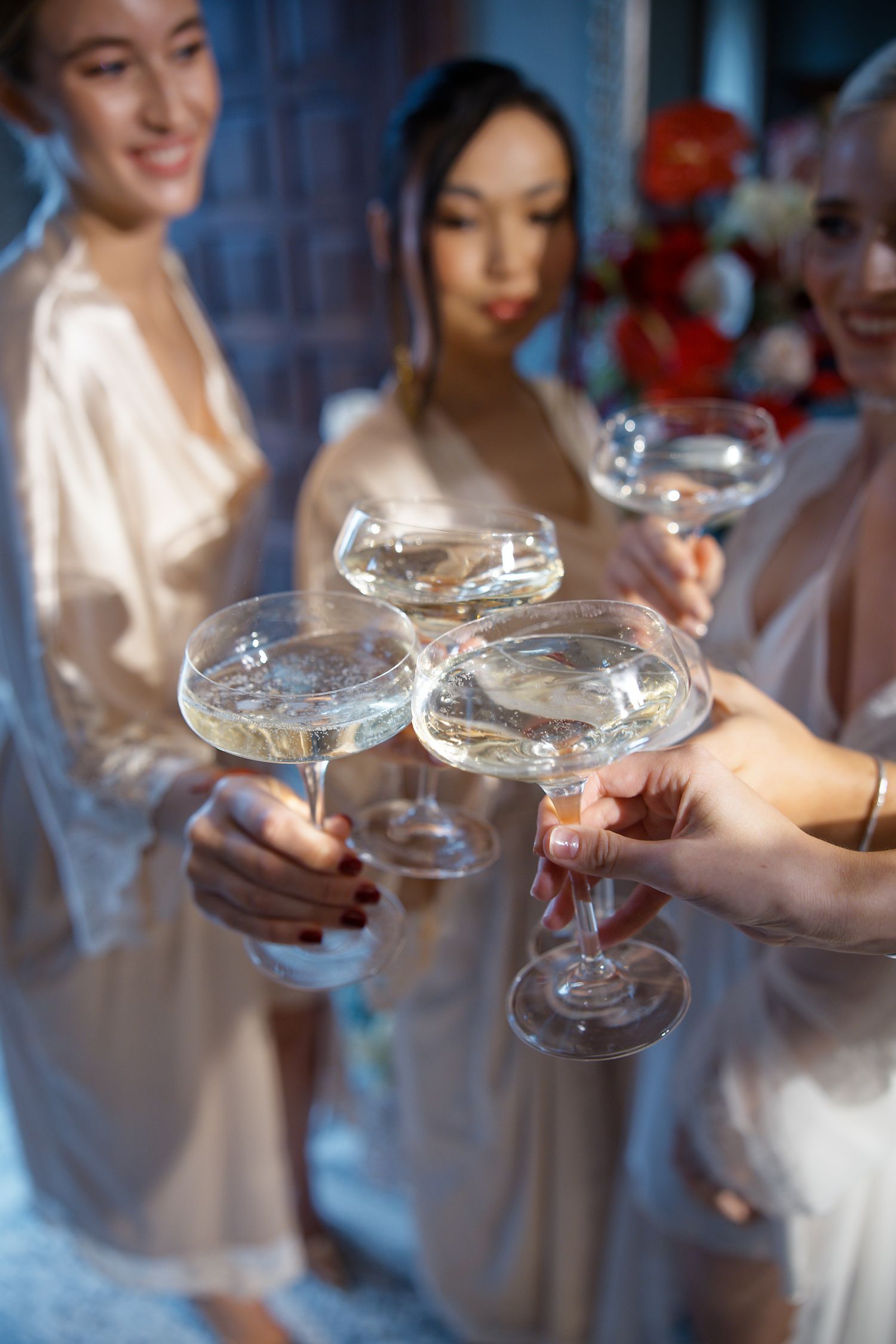 Wedding party toasting with champagne coupes in elegant setting.