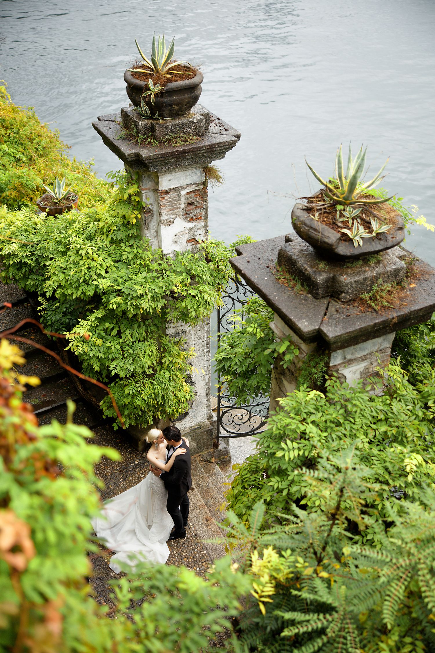 Beautiful garden scene with stone pillars and lush greenery surrounding a scenic overlook.