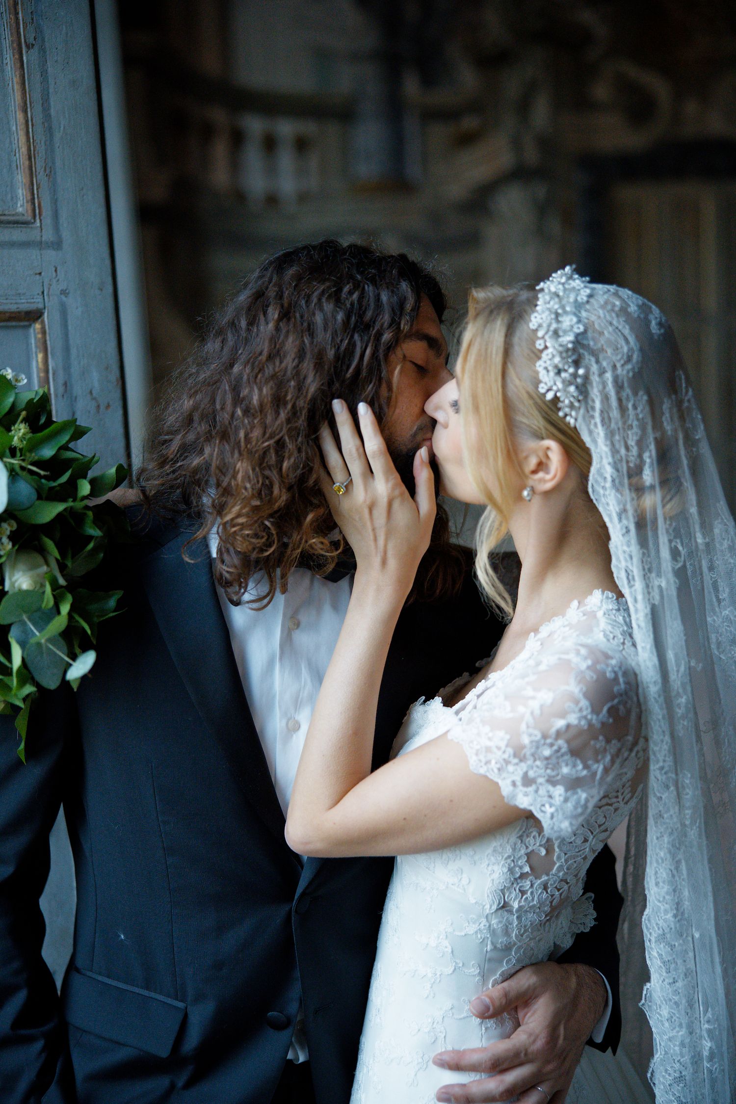 An intimate wedding moment captured between newlyweds in a vintage doorway setting.