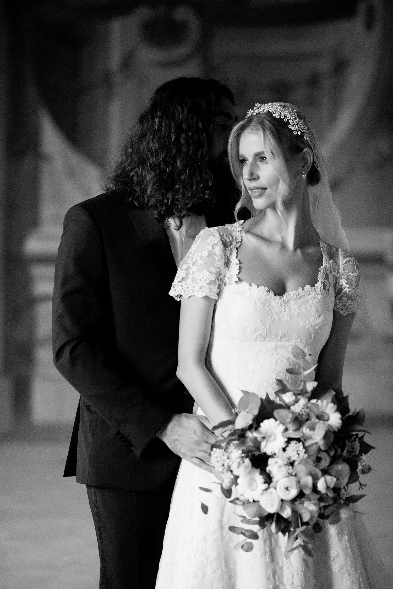 A romantic black and white wedding portrait captured on an ornate staircase with elegant decor.