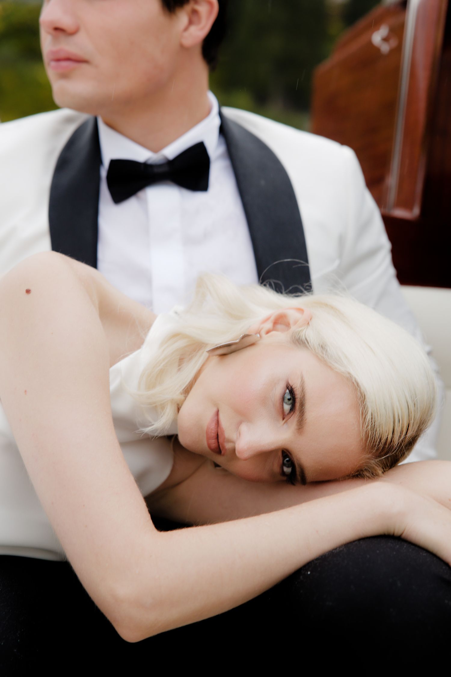 A romantic wedding portrait featuring a couple in formal attire with classic black and white styling.