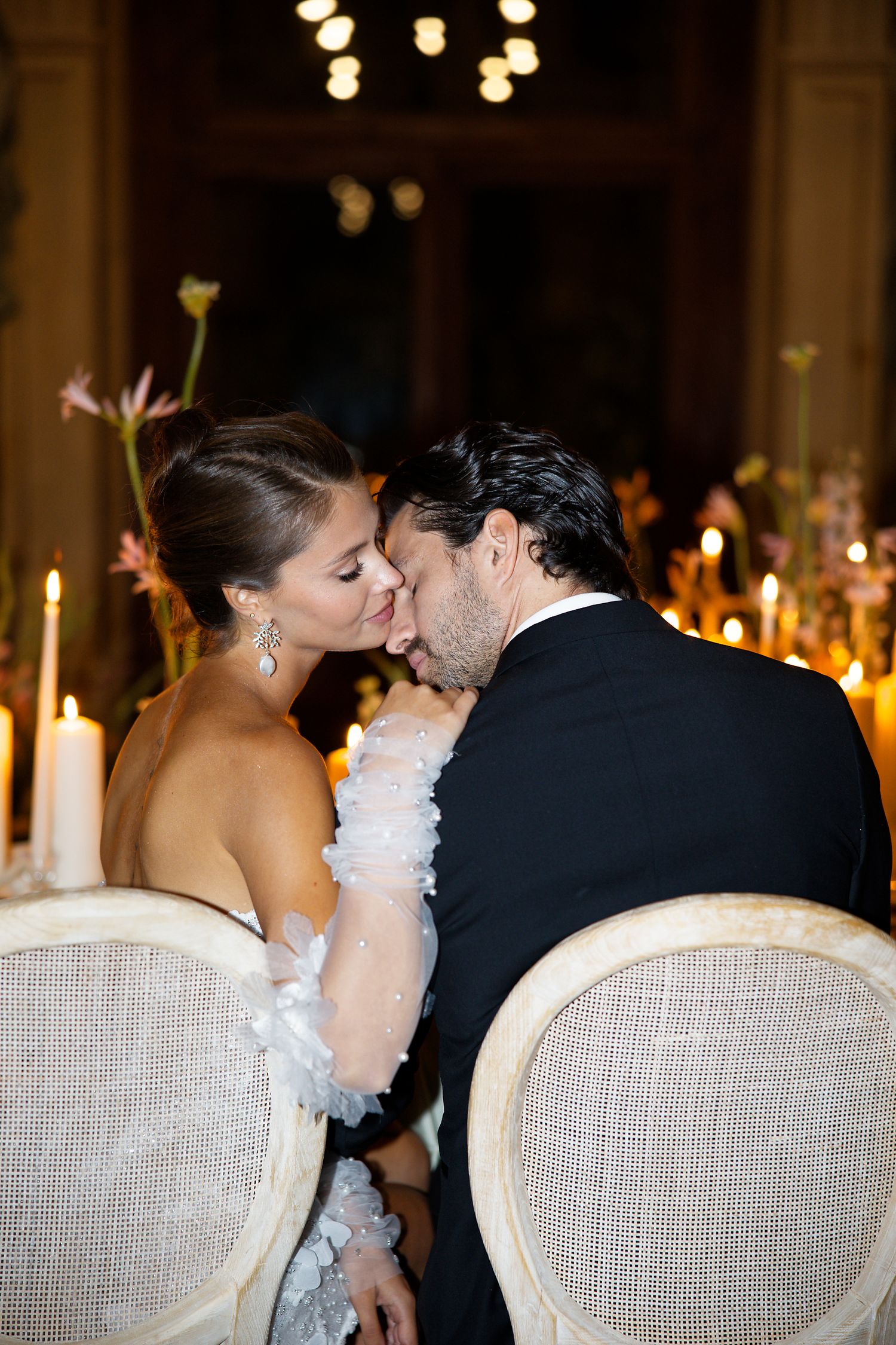 Intimate moment shared between couple at candlelit wedding reception.