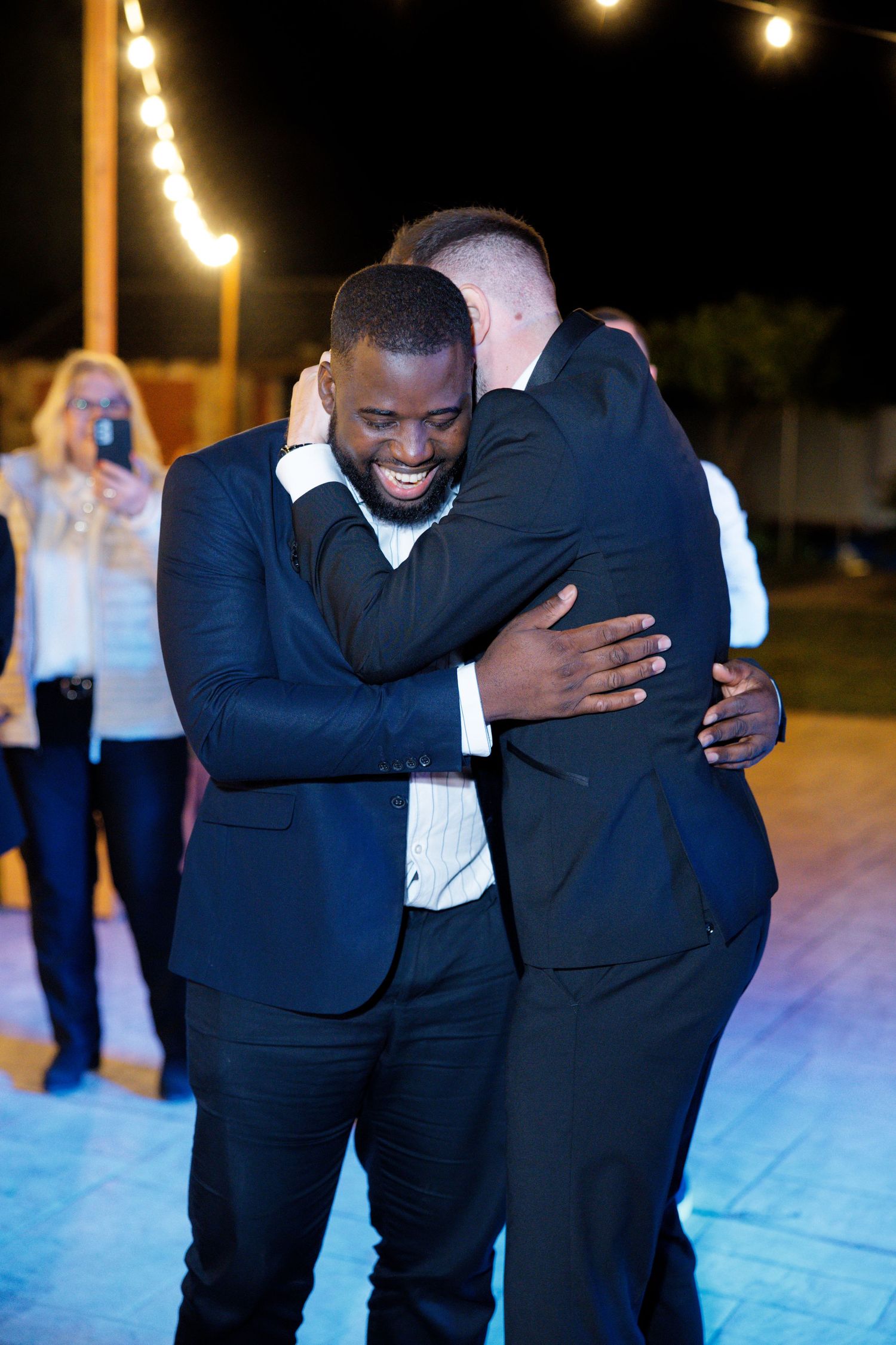 Friends sharing a joyful moment on the dance floor during an evening celebration.