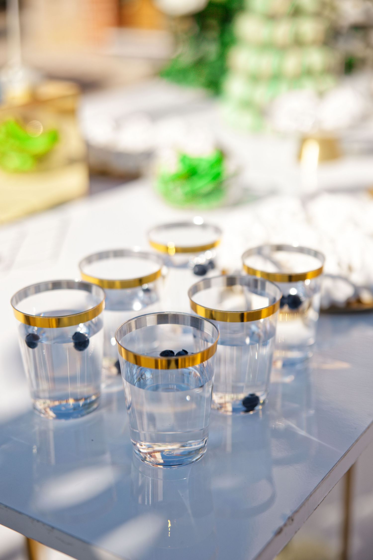 Elegant wedding table settings with gold-rimmed glasses and delicate decorations in soft lighting.
