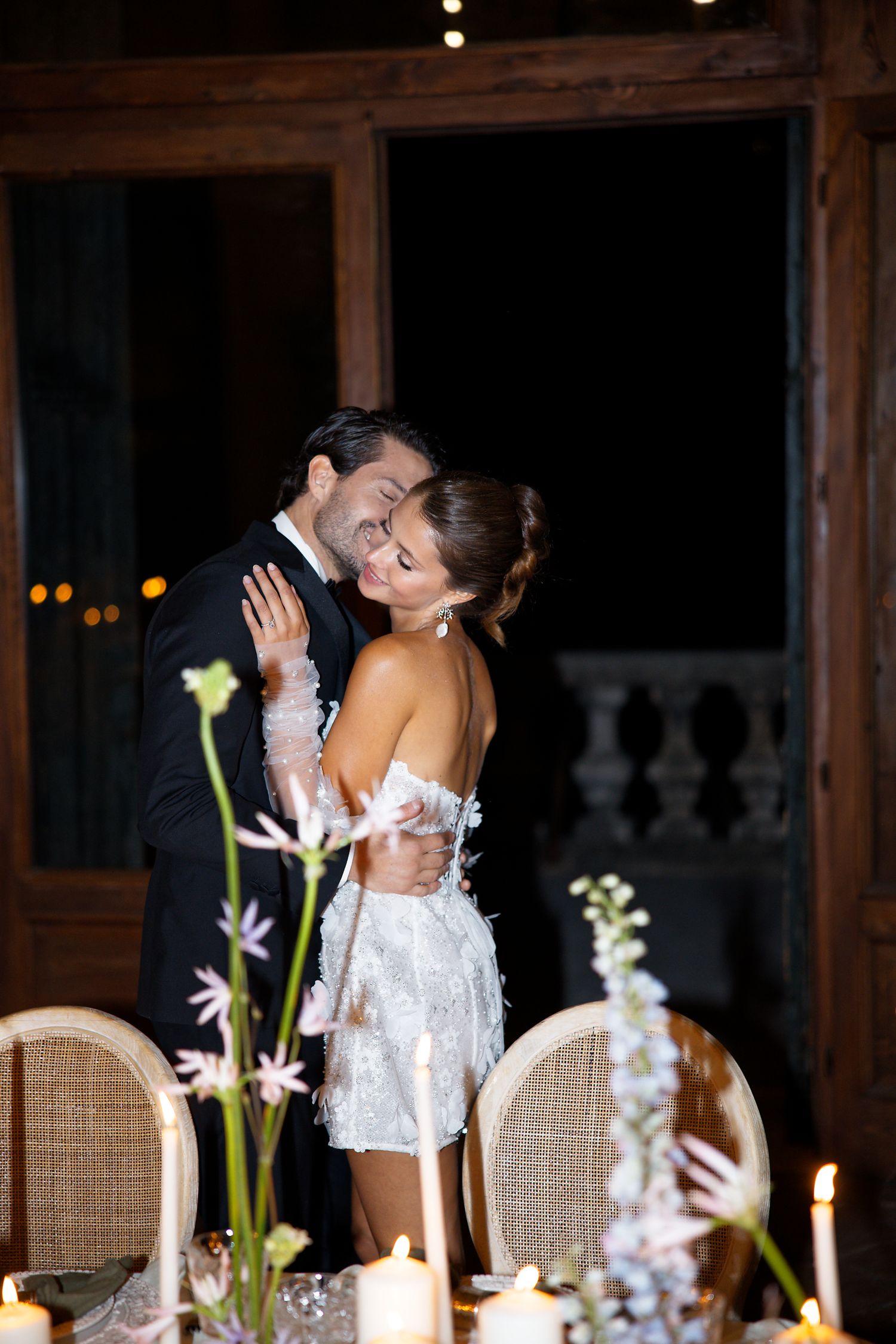 Intimate dance moment captured between newlyweds at candlelit reception.