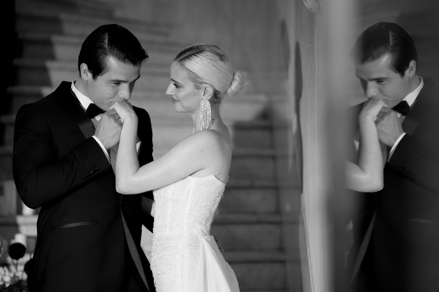 Black and white romantic wedding photo with couple's reflection in mirror.