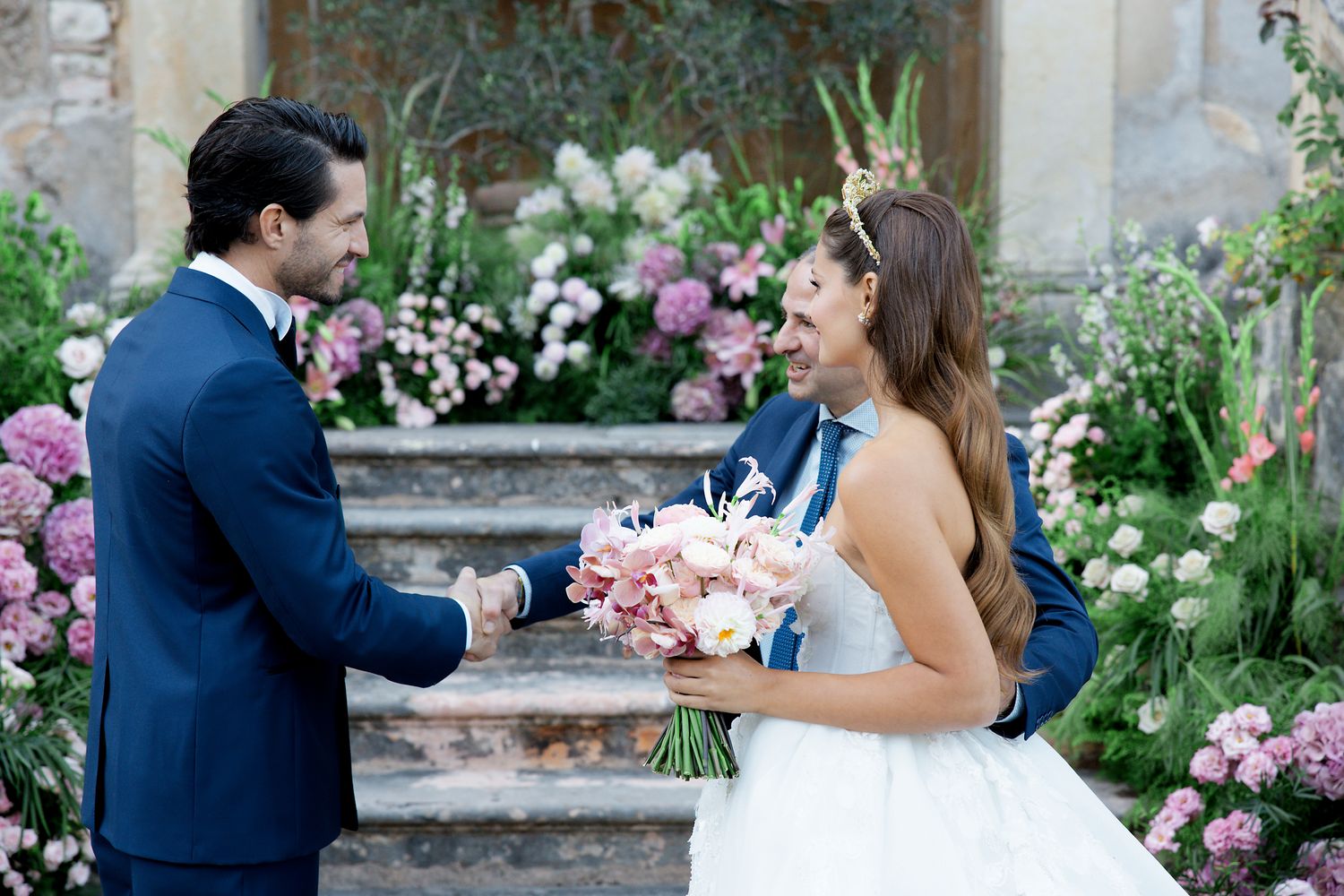 A romantic moment captured at a wedding with a bouquet of pink flowers on garden steps.