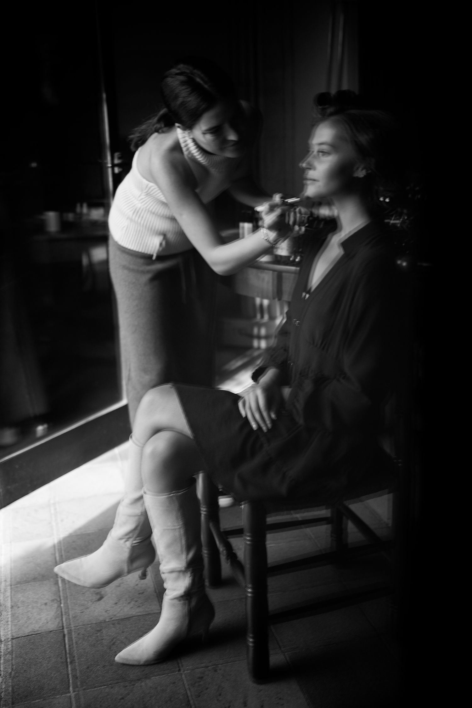 Vintage black and white photo showing makeup and hair preparation backstage.