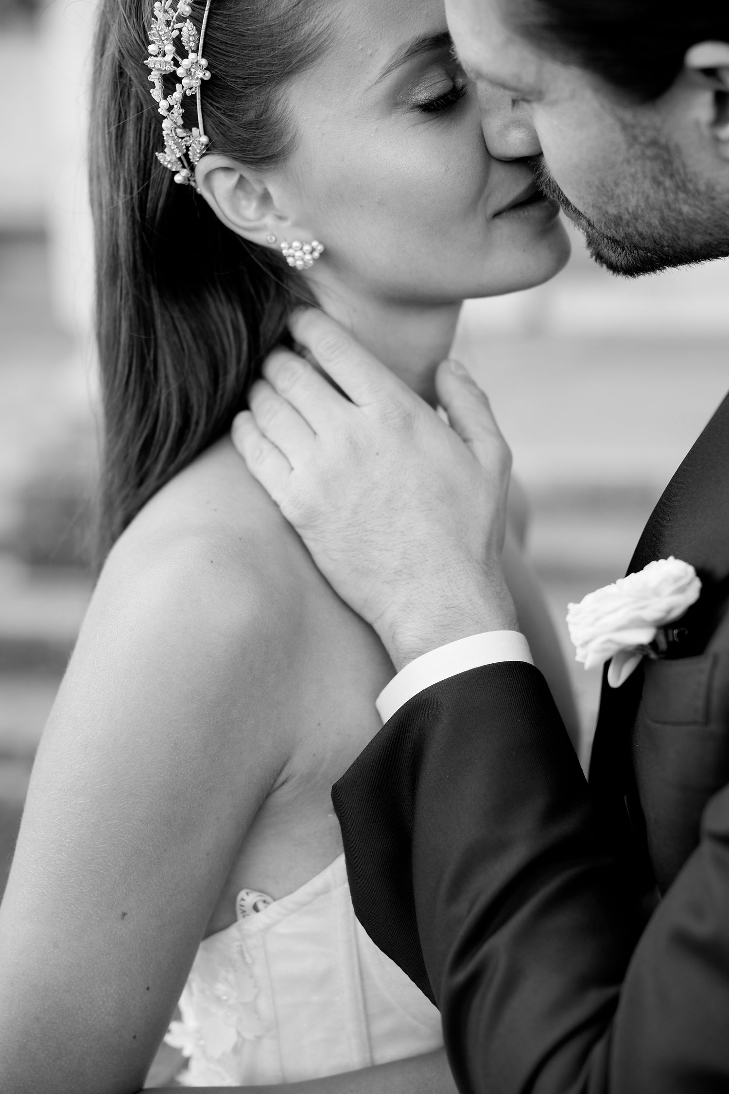 Intimate black and white portrait of a romantic wedding couple sharing a tender moment.