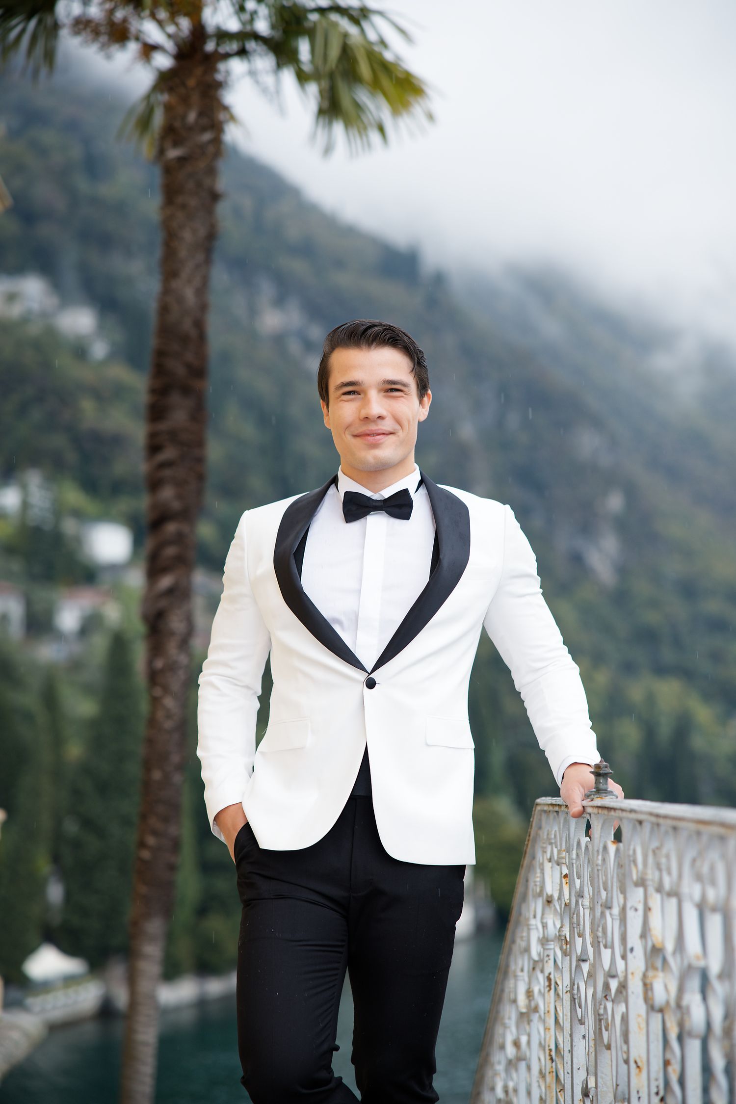 White dinner jacket and bow tie formal wear photographed on Mediterranean terrace with palm trees.