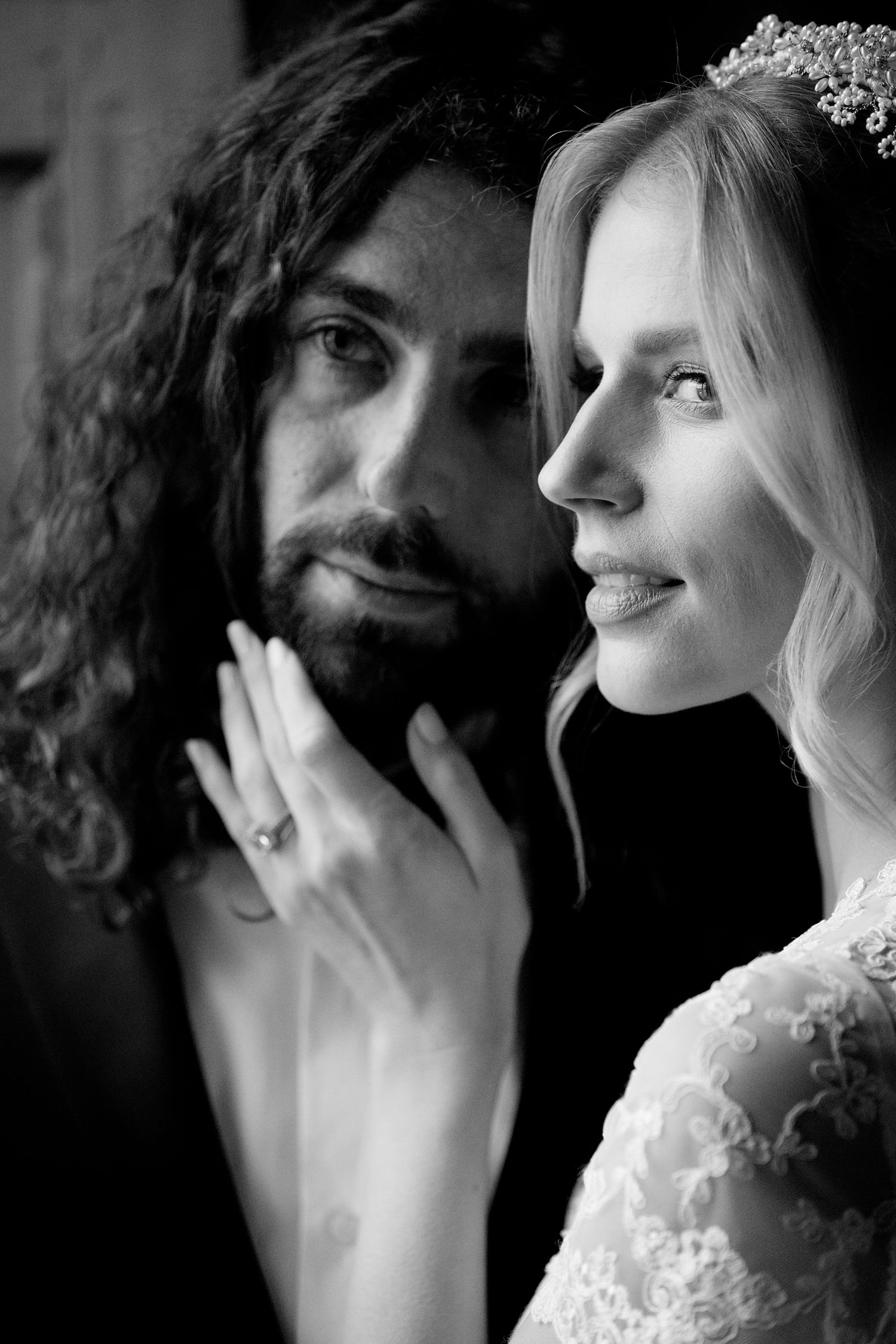 An artistic black and white portrait of newlyweds sharing a tender moment.
