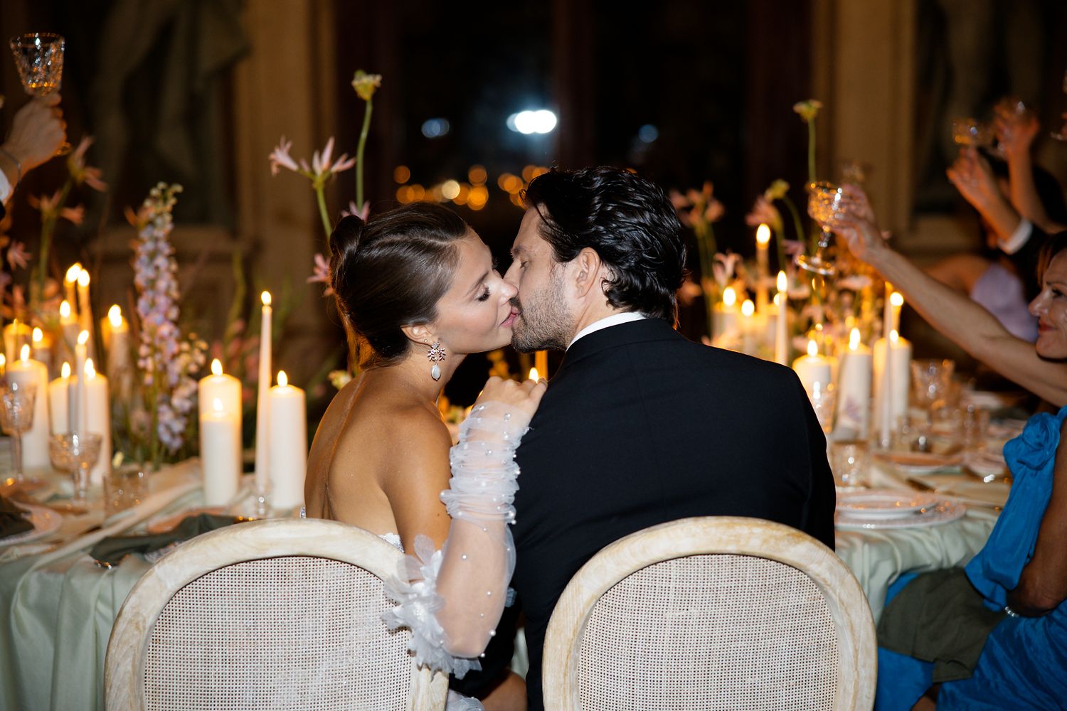 Romantic candlelit wedding reception dinner with elegant table settings and decorations.