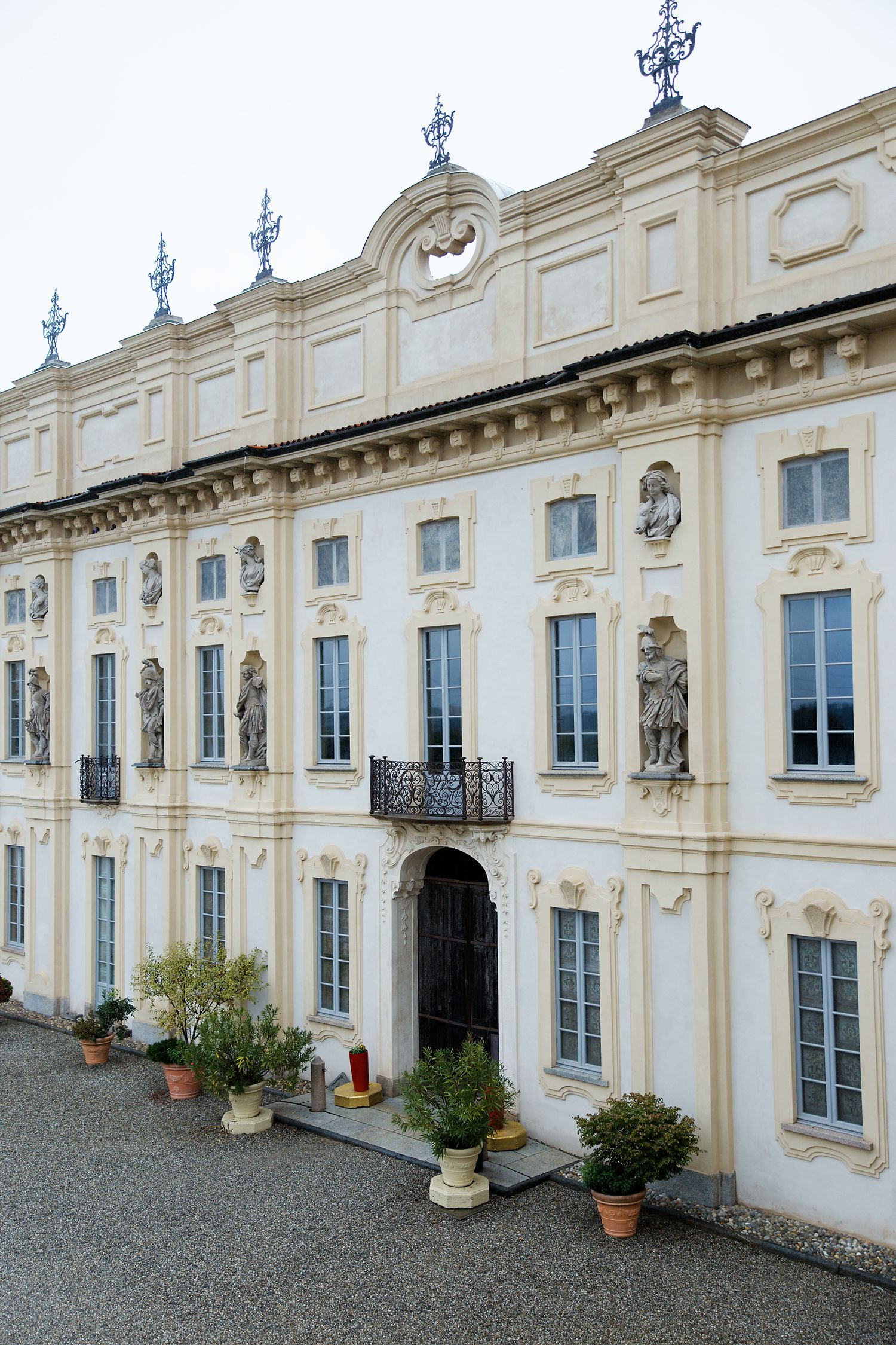 Elegant baroque-style palace facade with ornate white stonework, statues, and decorative blue finials.