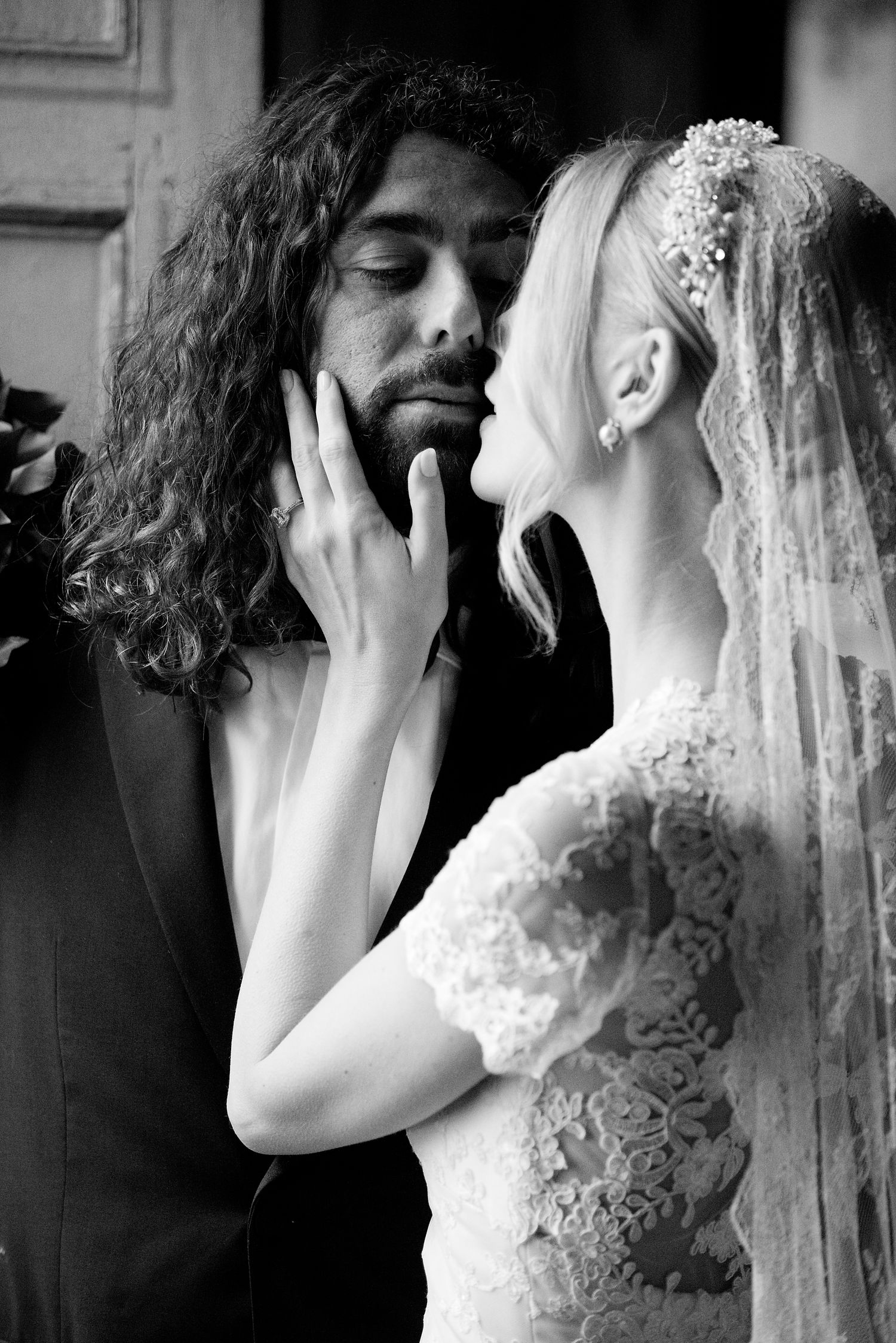 An intimate black and white portrait of a bride and groom sharing a tender moment.
