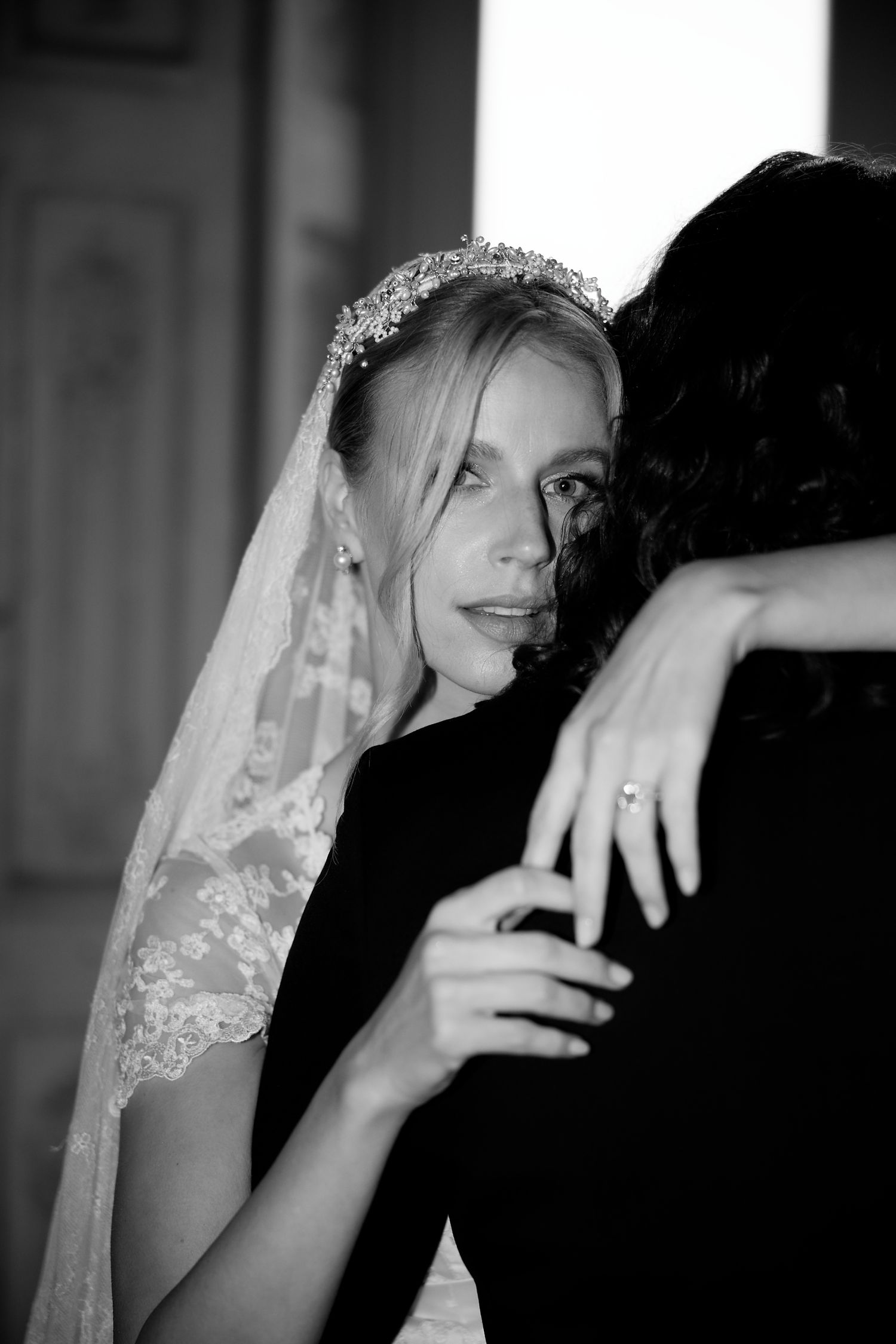An intimate black and white wedding portrait capturing a tender embrace between newlyweds.