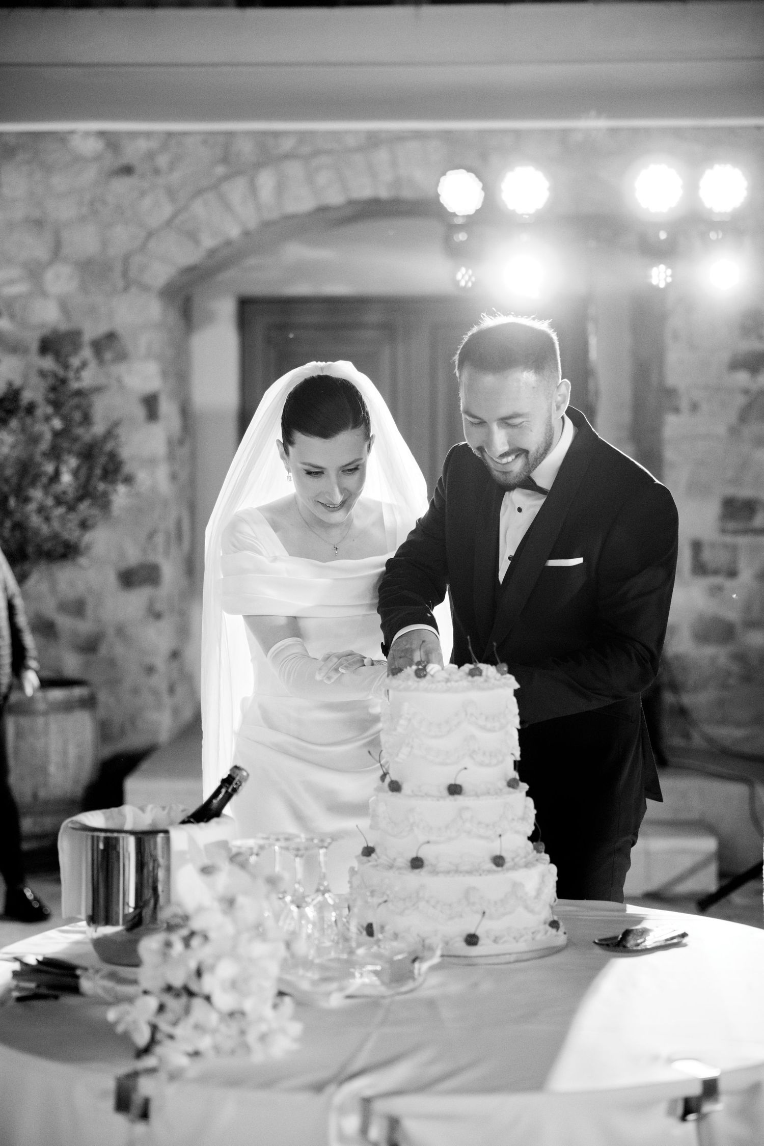 Black and white photos of couple cutting their wedding cake at reception.