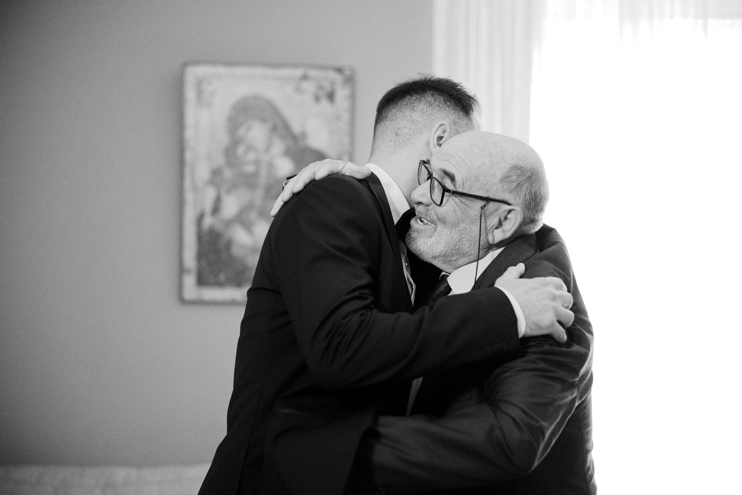 Black and white photographs showing emotional embraces at a wedding celebration.