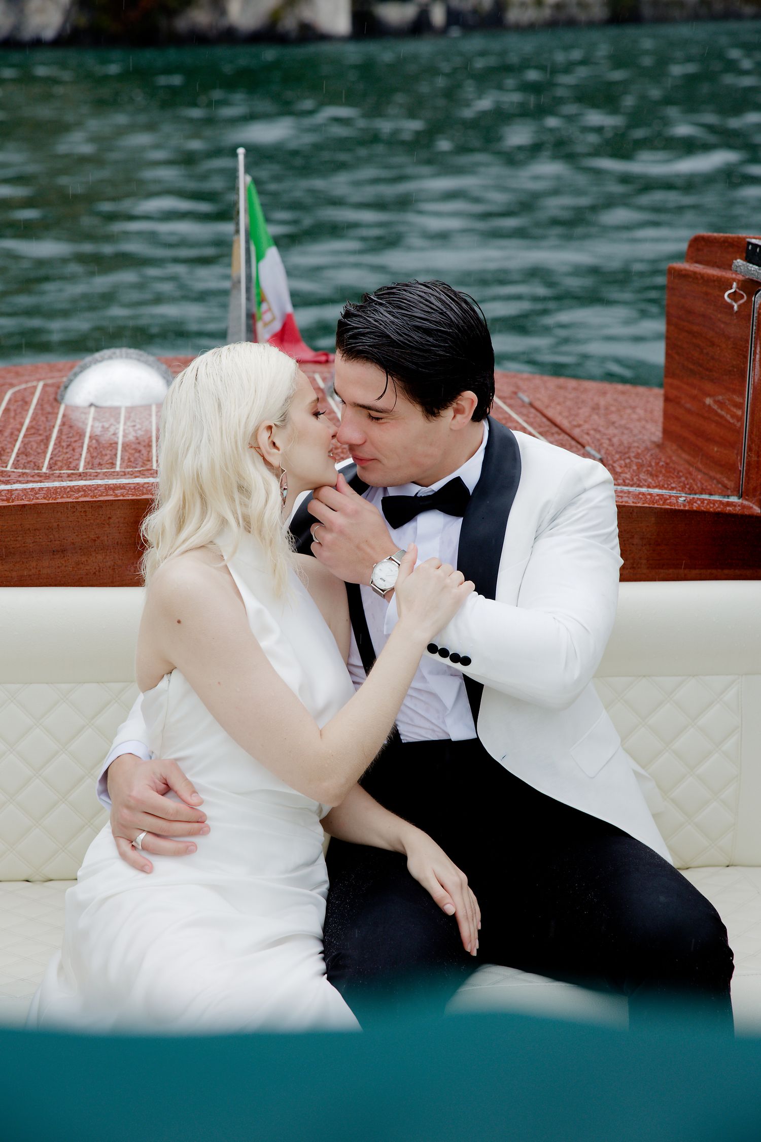 Romantic moment on a wooden boat with Italian flag showing in background.