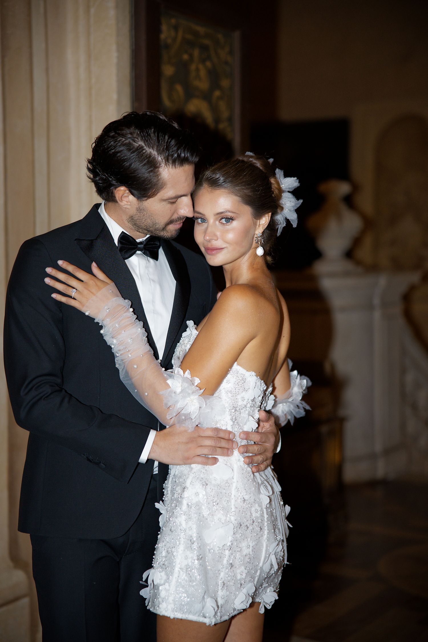 Couple in formal attire sharing romantic dance moment at formal event.