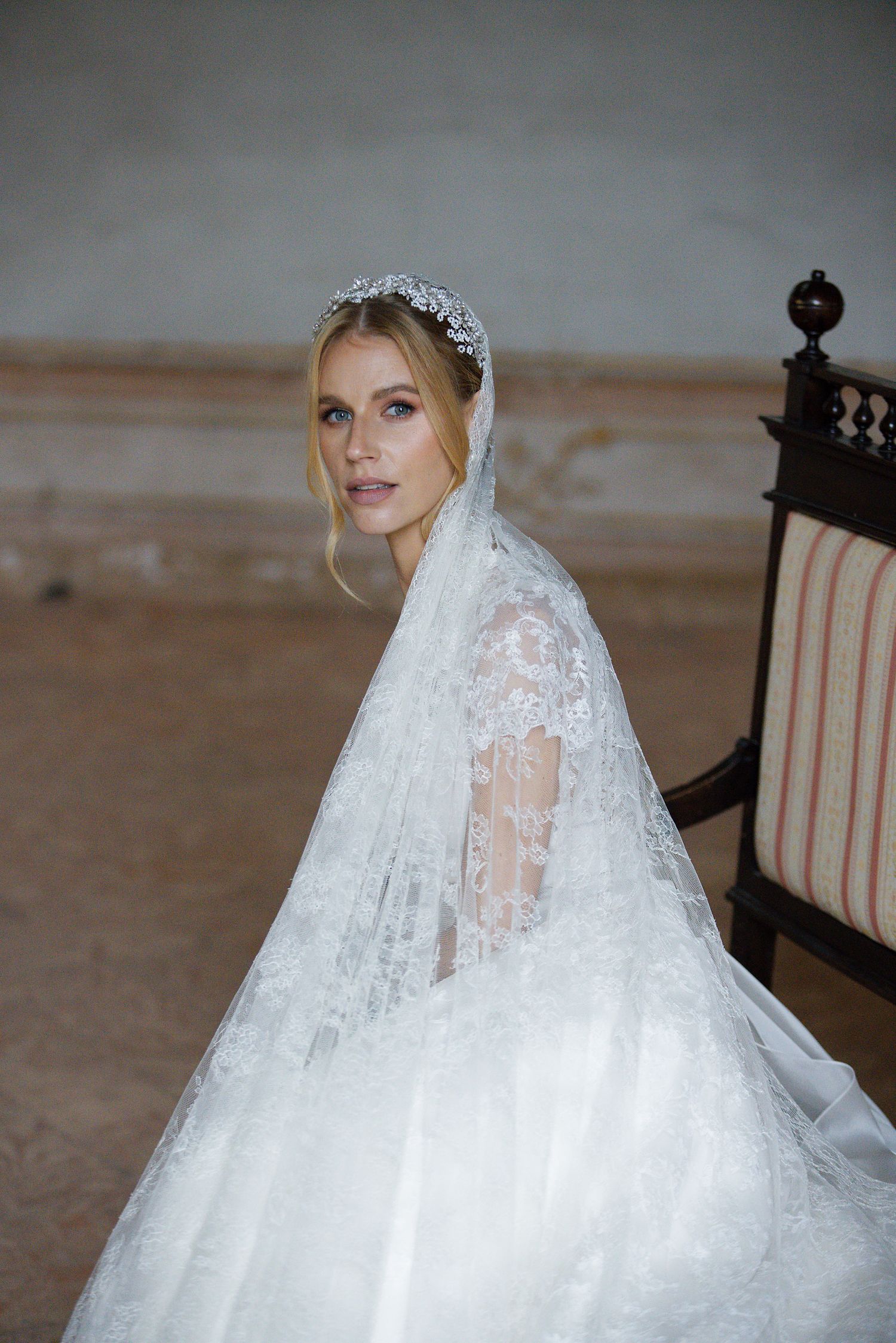 Classic bridal portrait featuring lace veil and elegant tiara.