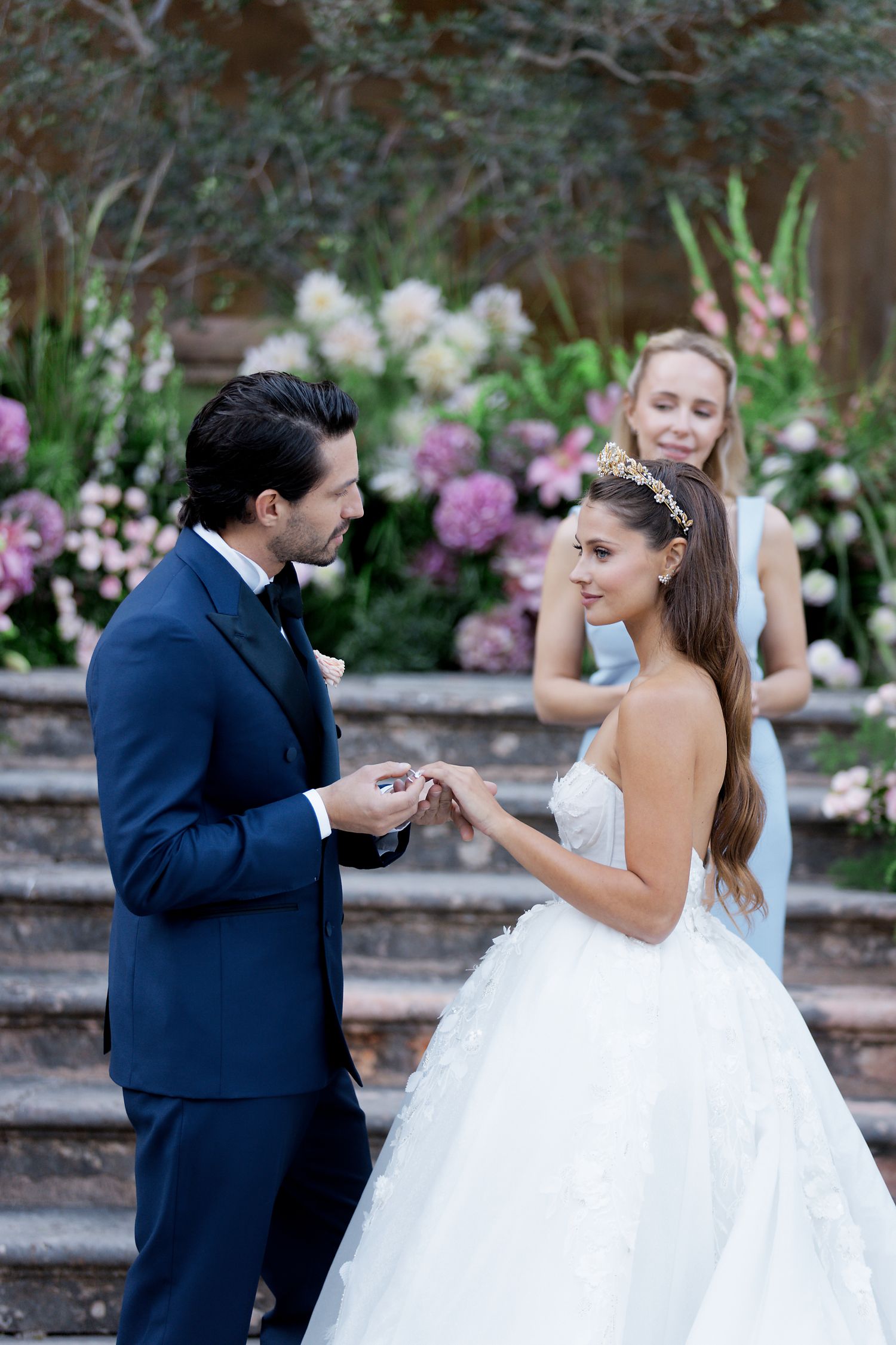 A special moment shared on stone steps surrounded by beautiful floral arrangements.