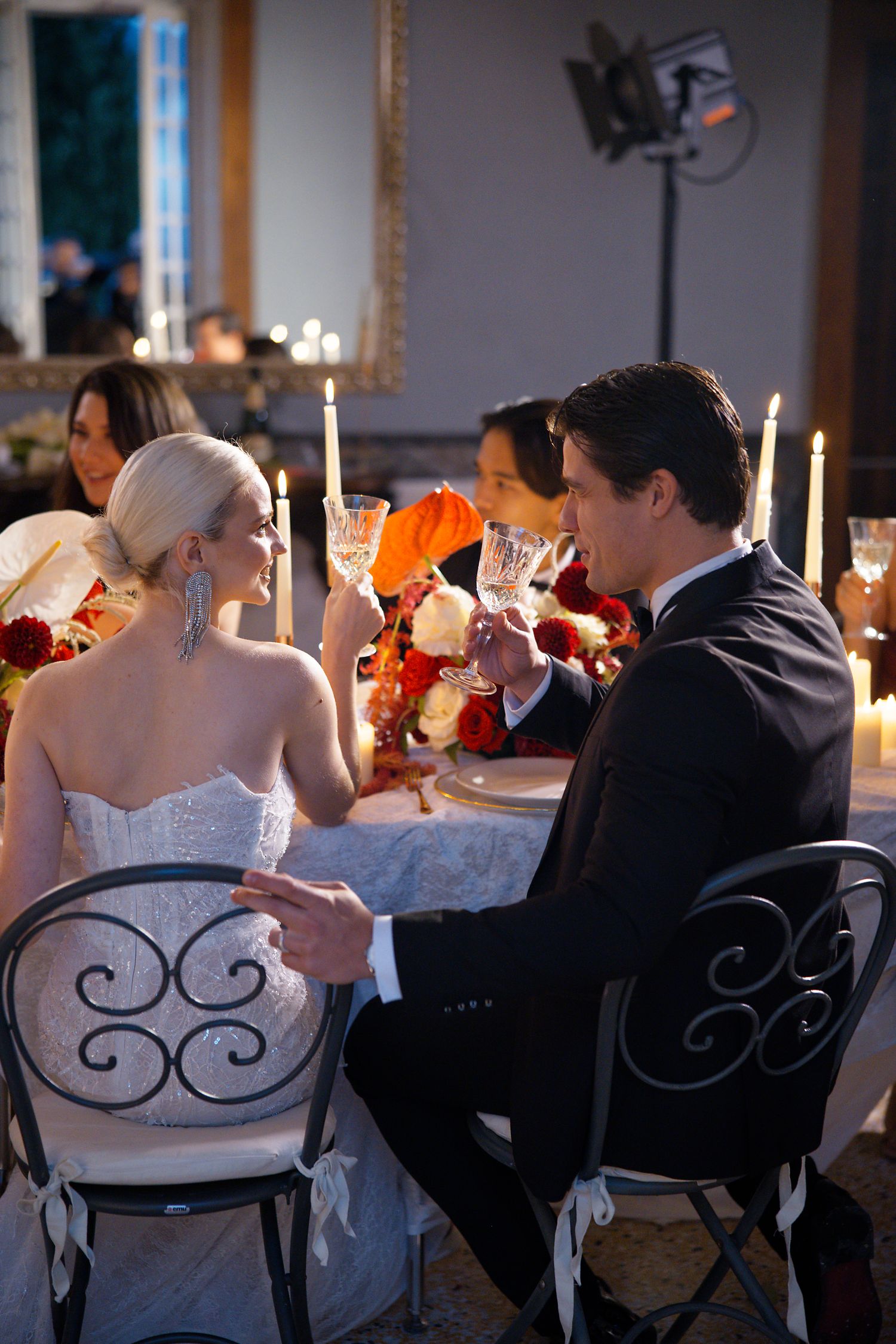 Elegant candlelit wedding reception dinner with romantic table setting and decor.