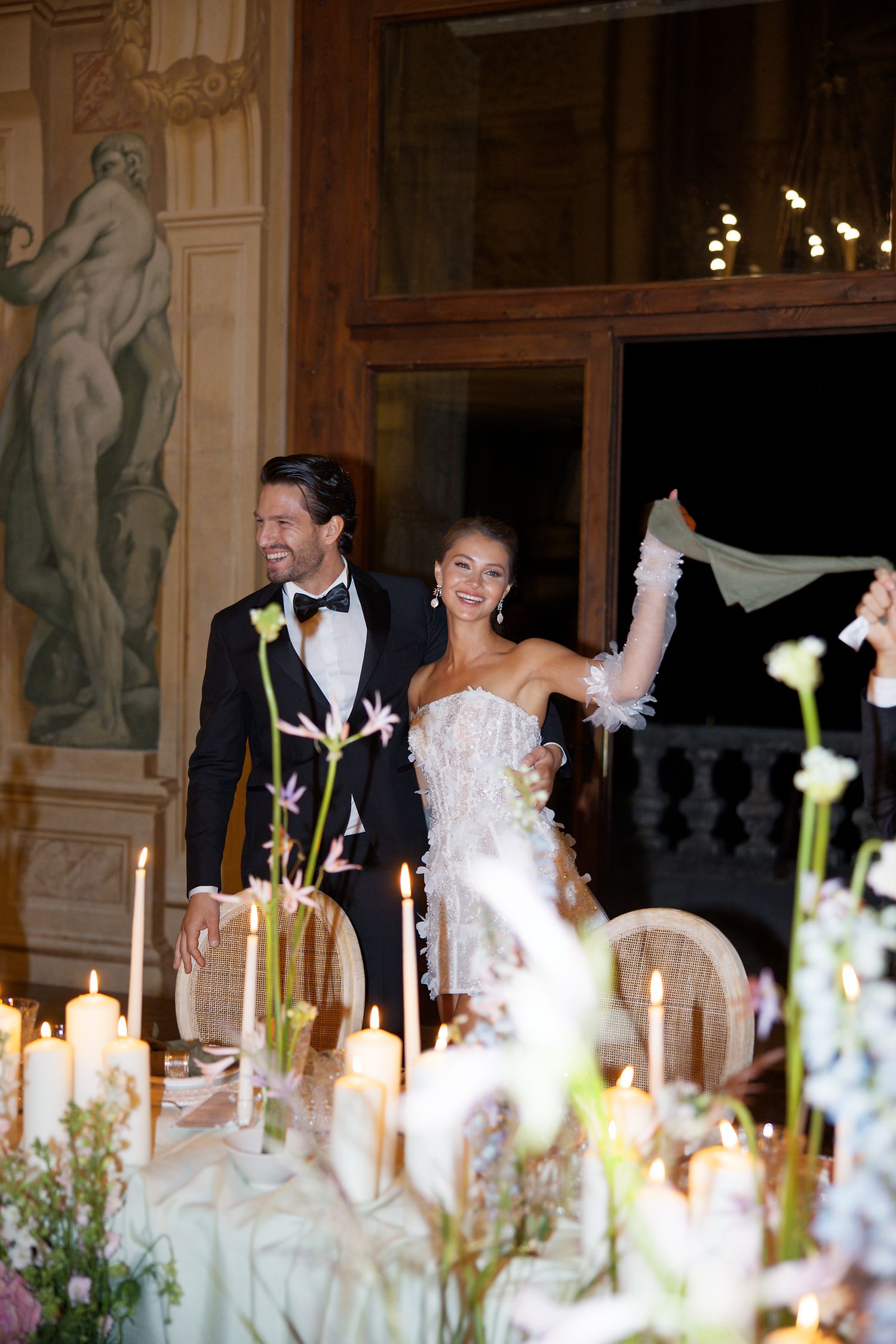 Joyful celebration moment at elegant candlelit reception dinner.