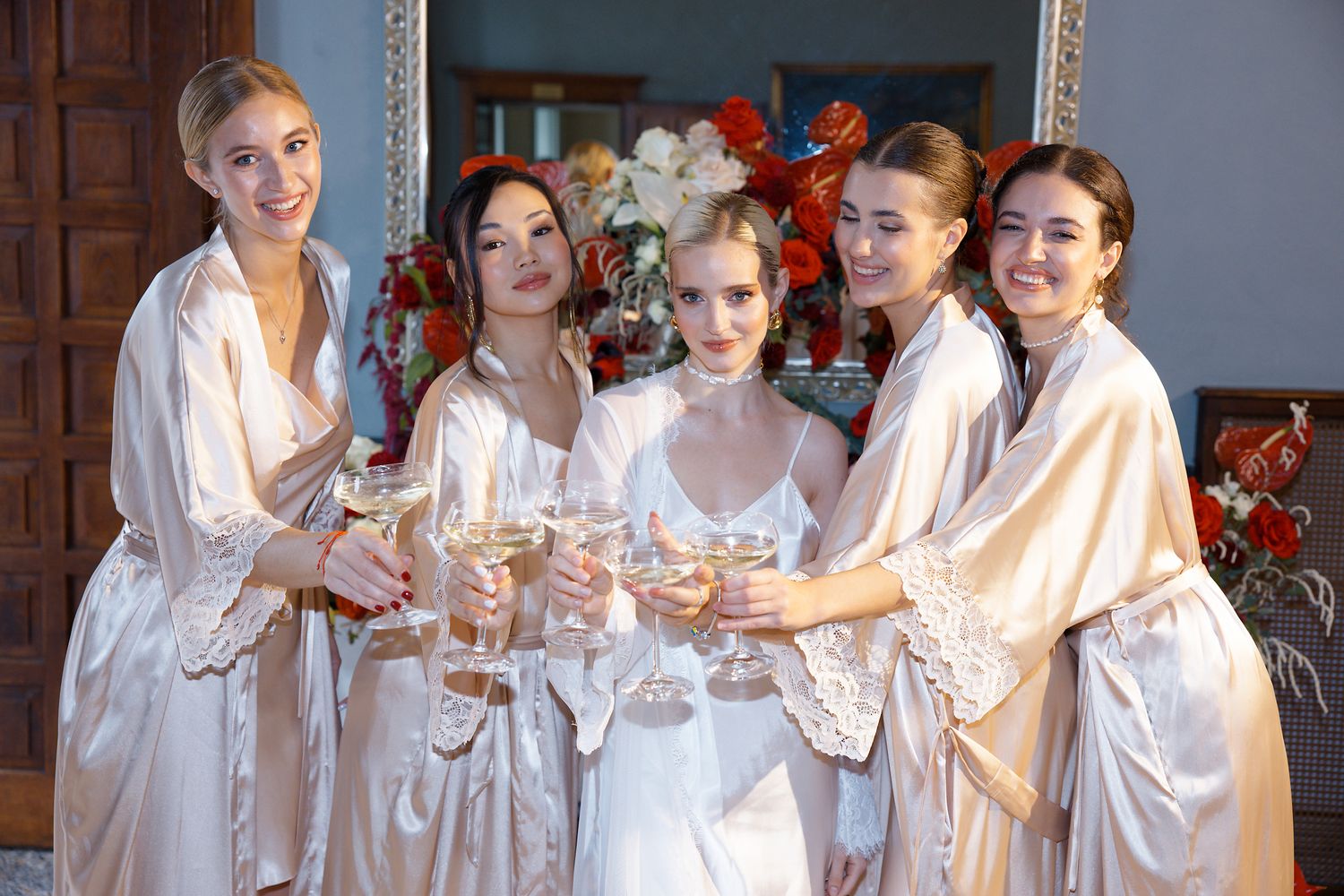 Group in silk robes raising champagne glasses in celebration.