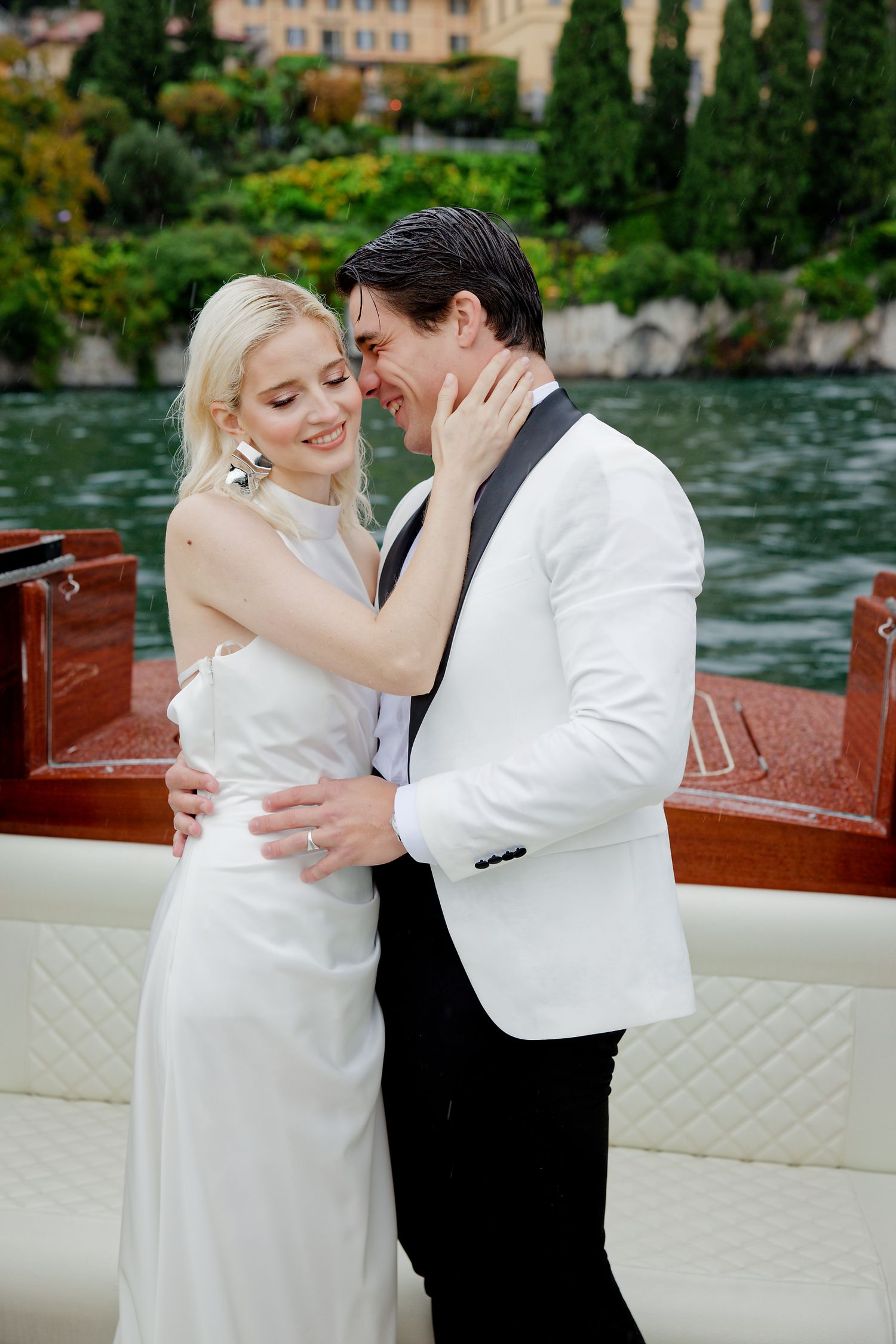 A romantic moment captured on a wooden boat with Italian lake scenery.
