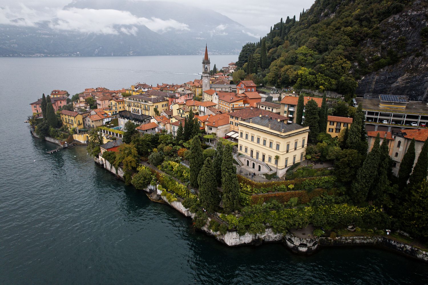 Aerial view of the picturesque lakeside village of Varenna on Lake Como, Italy, with traditional buildings and a church spire.