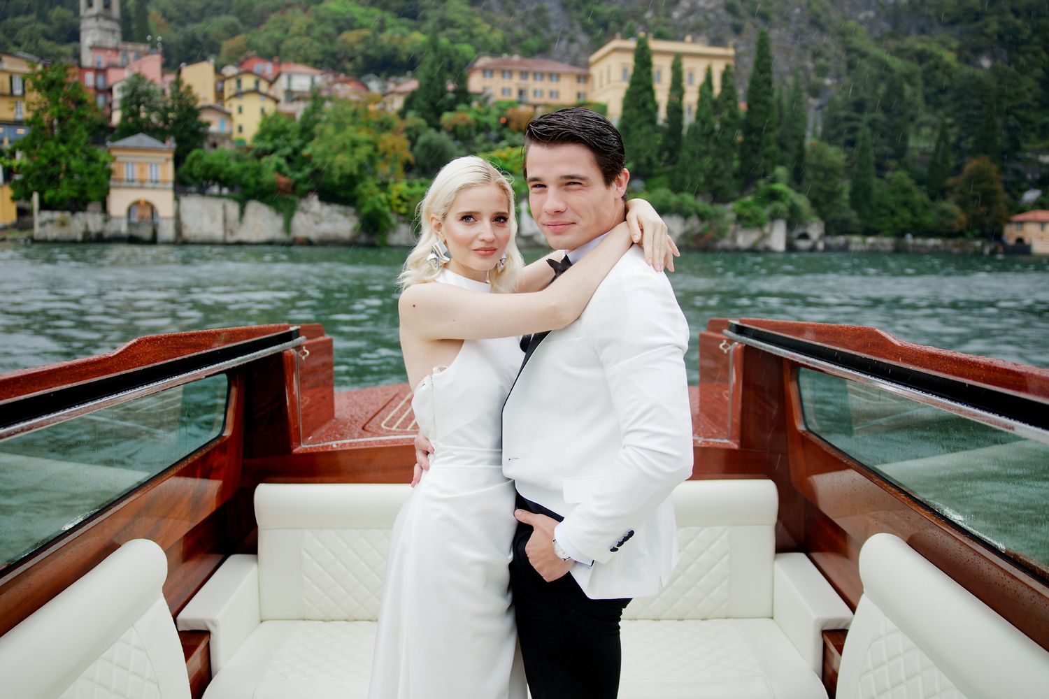 Wedding couple shares intimate moment aboard classic wooden boat on Lake Como.