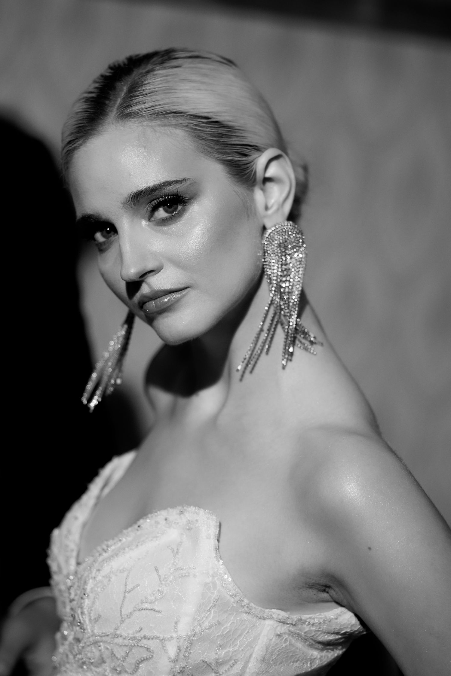 Dramatic black and white portrait showcasing sparkling statement earrings and elegant styling.