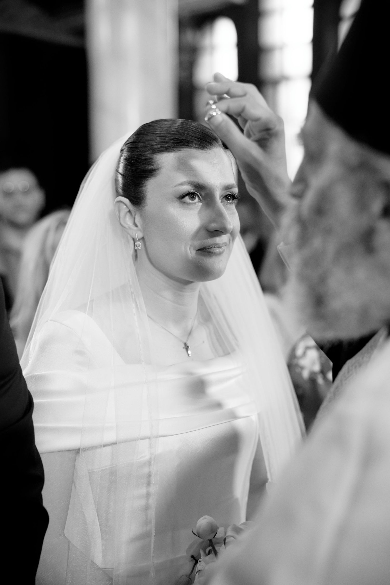 Black and white sequence of a bride in traditional white veil during wedding ceremony.