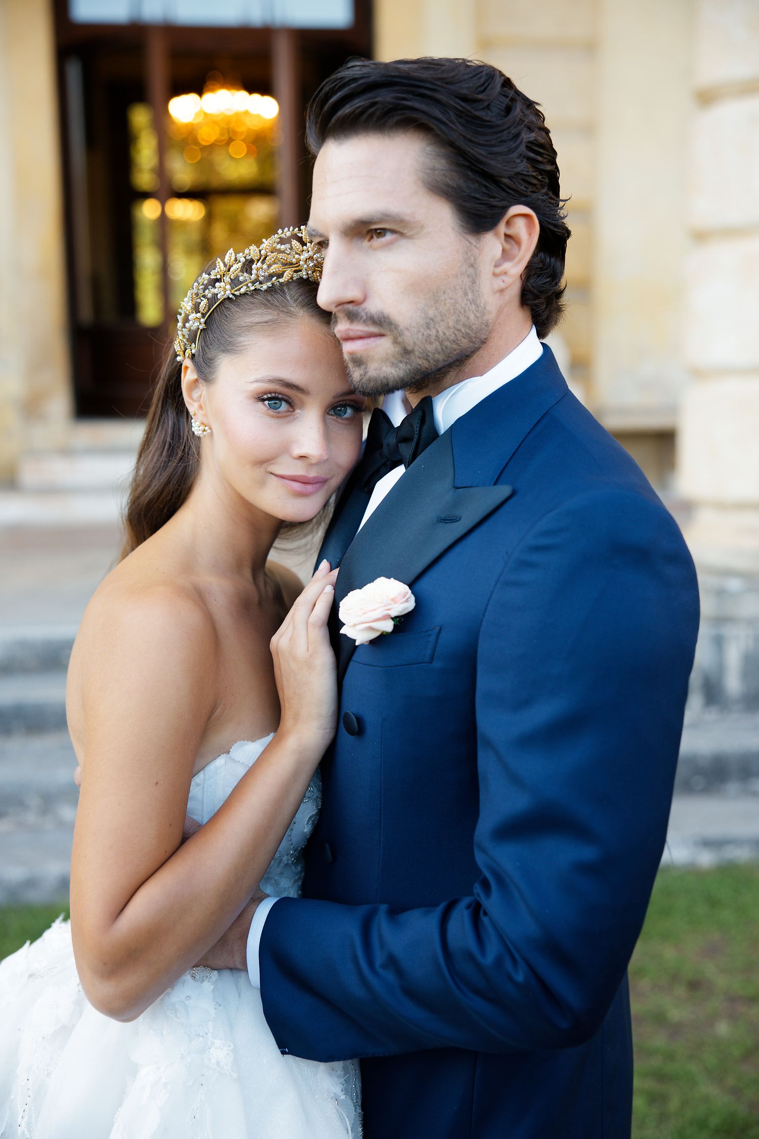 A romantic wedding portrait captured in front of an elegant historic building.