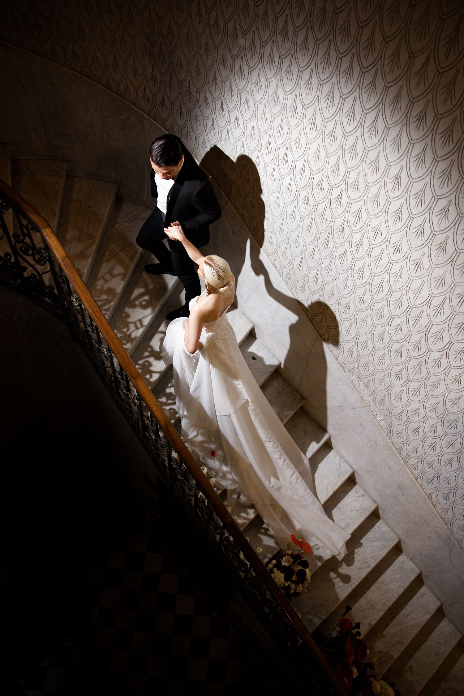 Dramatic staircase shot with shadows cast on textured wallpaper.