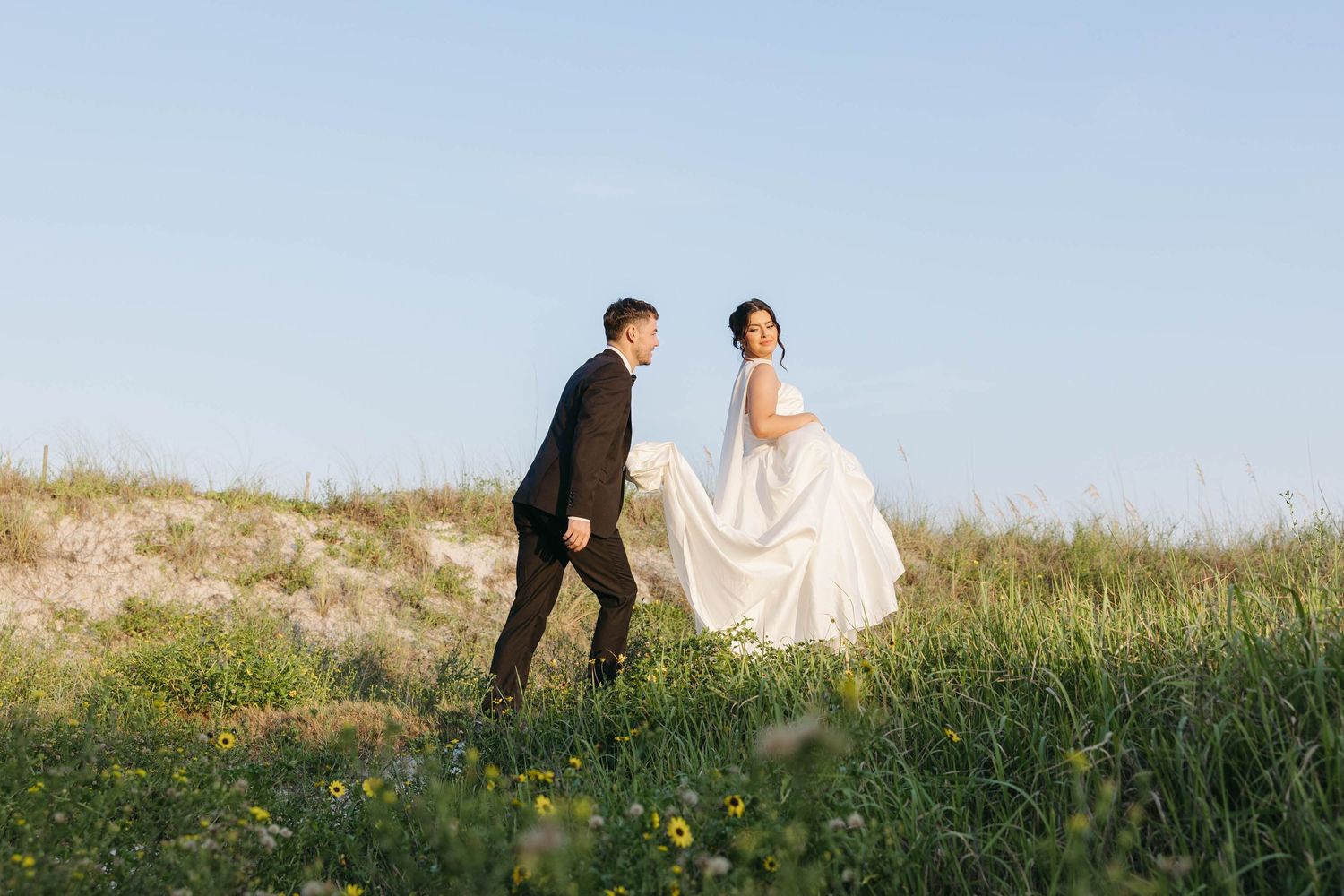 Birmingham Alabama Photographer capturing Bride and groom running in a field, at gulf shores beach in Alabama