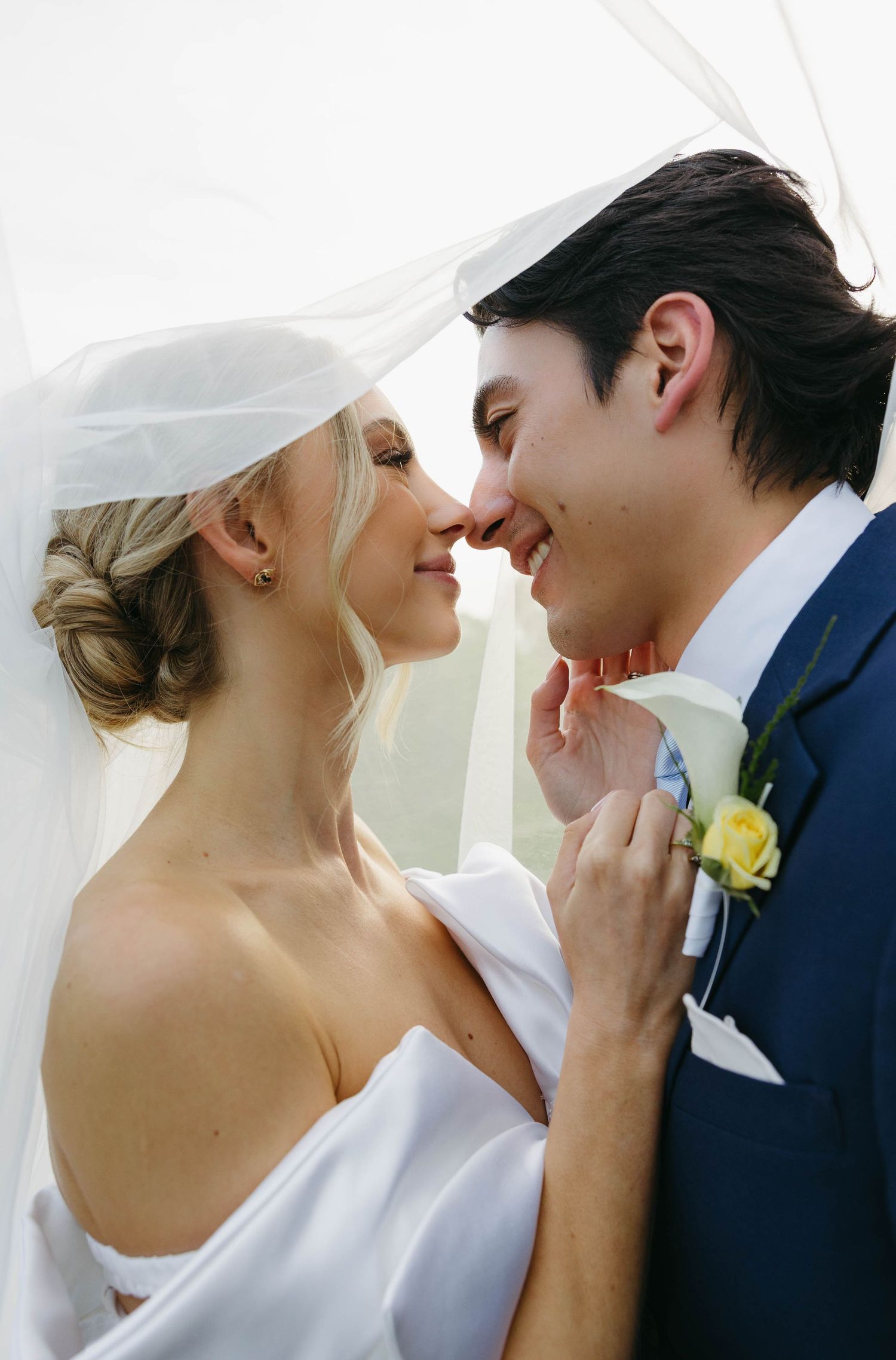 bride and groom kissing under veil